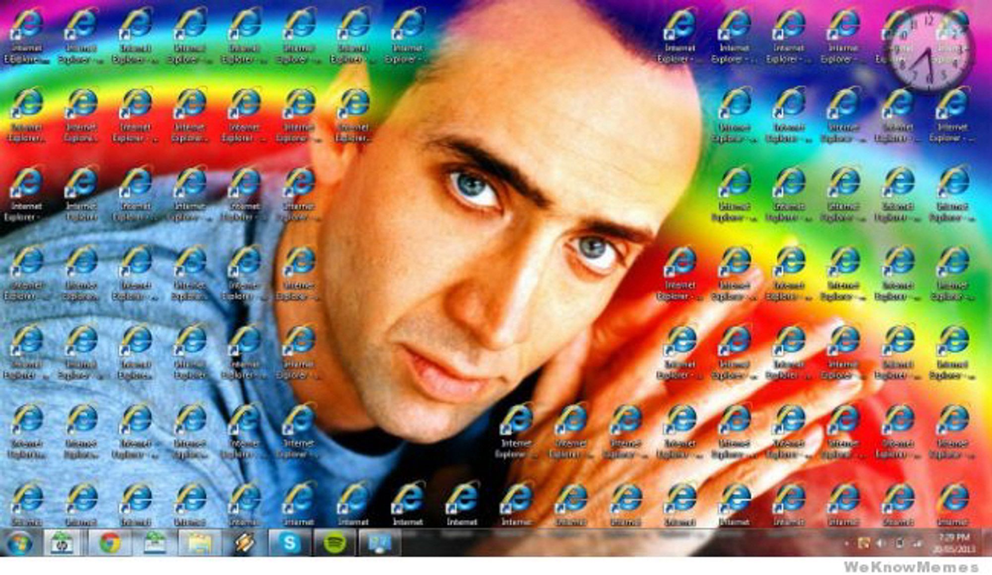 Image is screencap of somebody's Windows 10 desktop which is just an image of Nic Cage embracing a rainbow over his shoulder, the taskbar, and like 100 shortcuts to Internet Explorer cover everything but the part of the background that's Cage's face