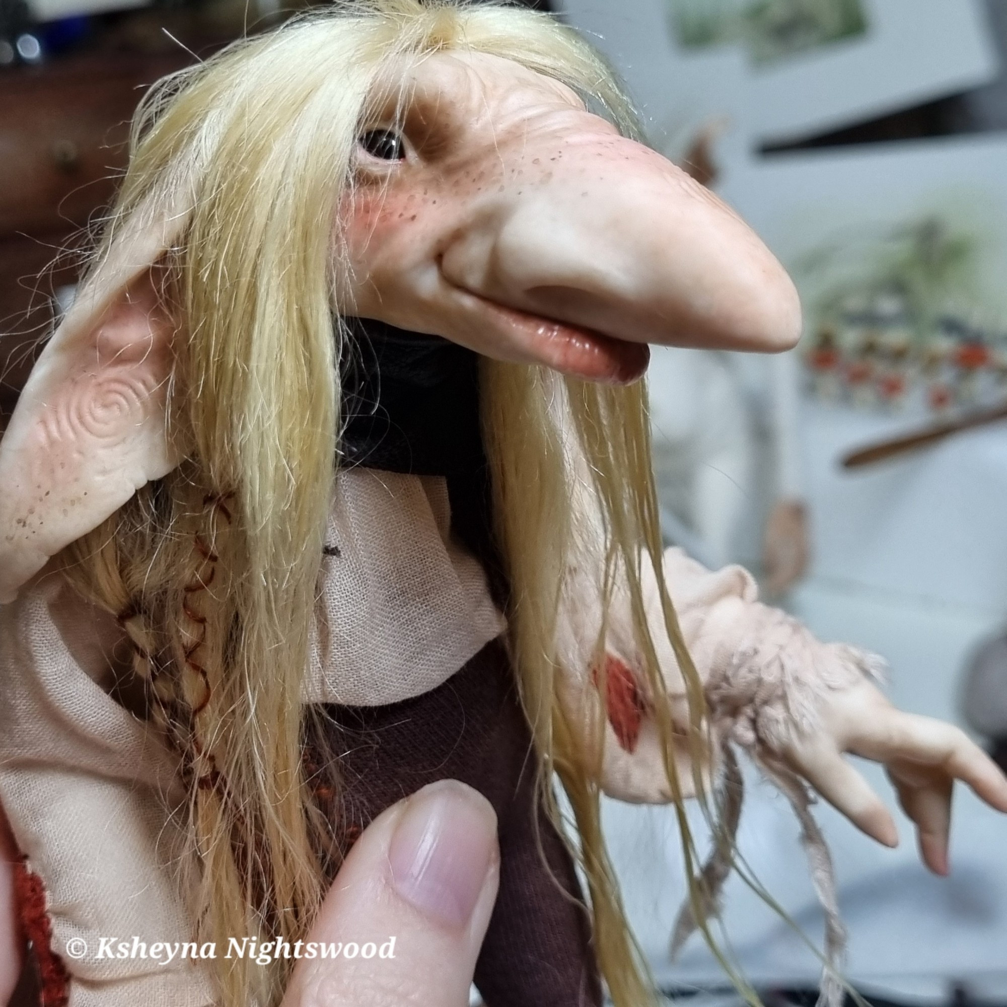 A (Scandinavian-inspired) troll art doll with long blonde hair, dressed in a pinkish-white shirt and brown pants.