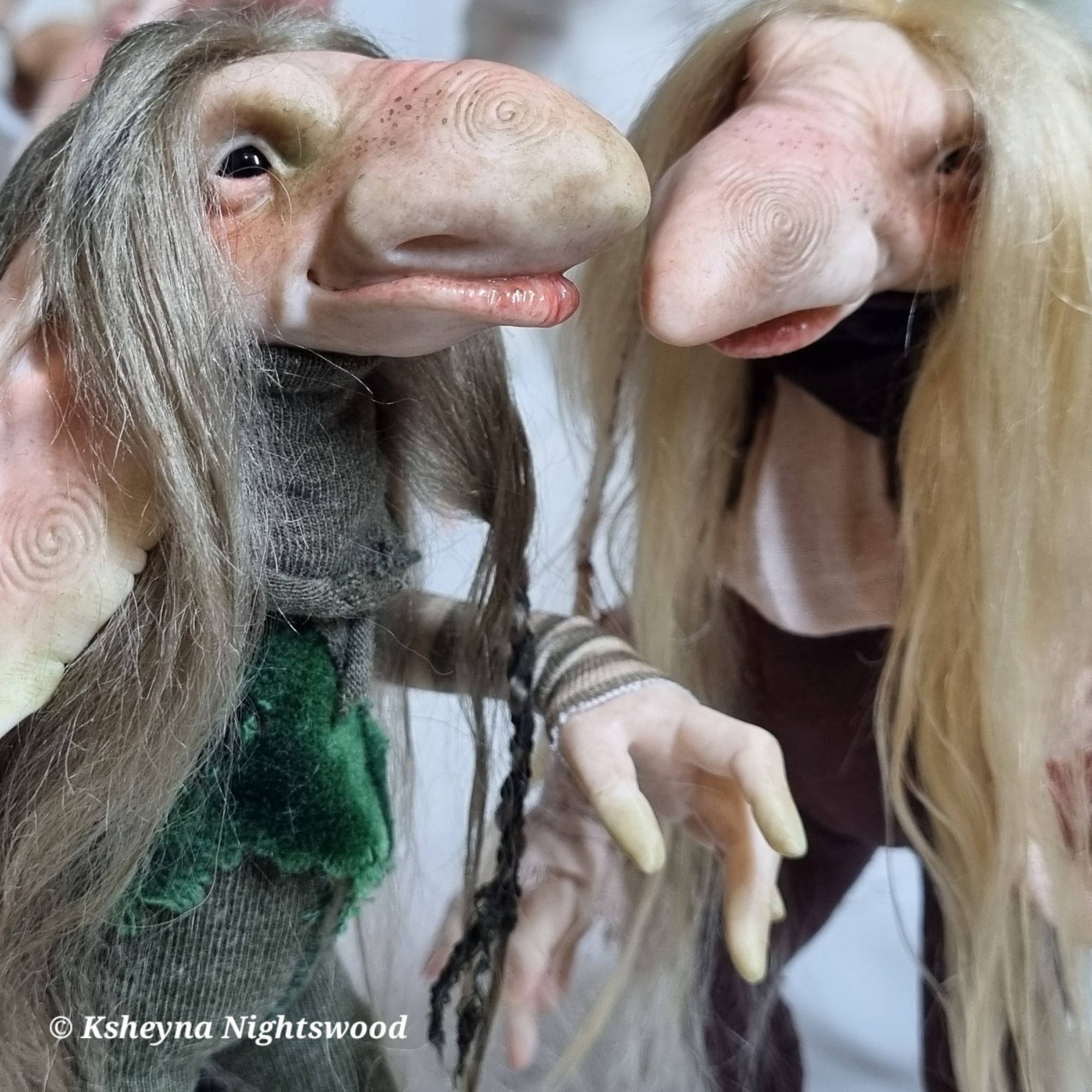 Two (Scandinavian-inspired) troll art dolls with long hair and spirals on their noses.