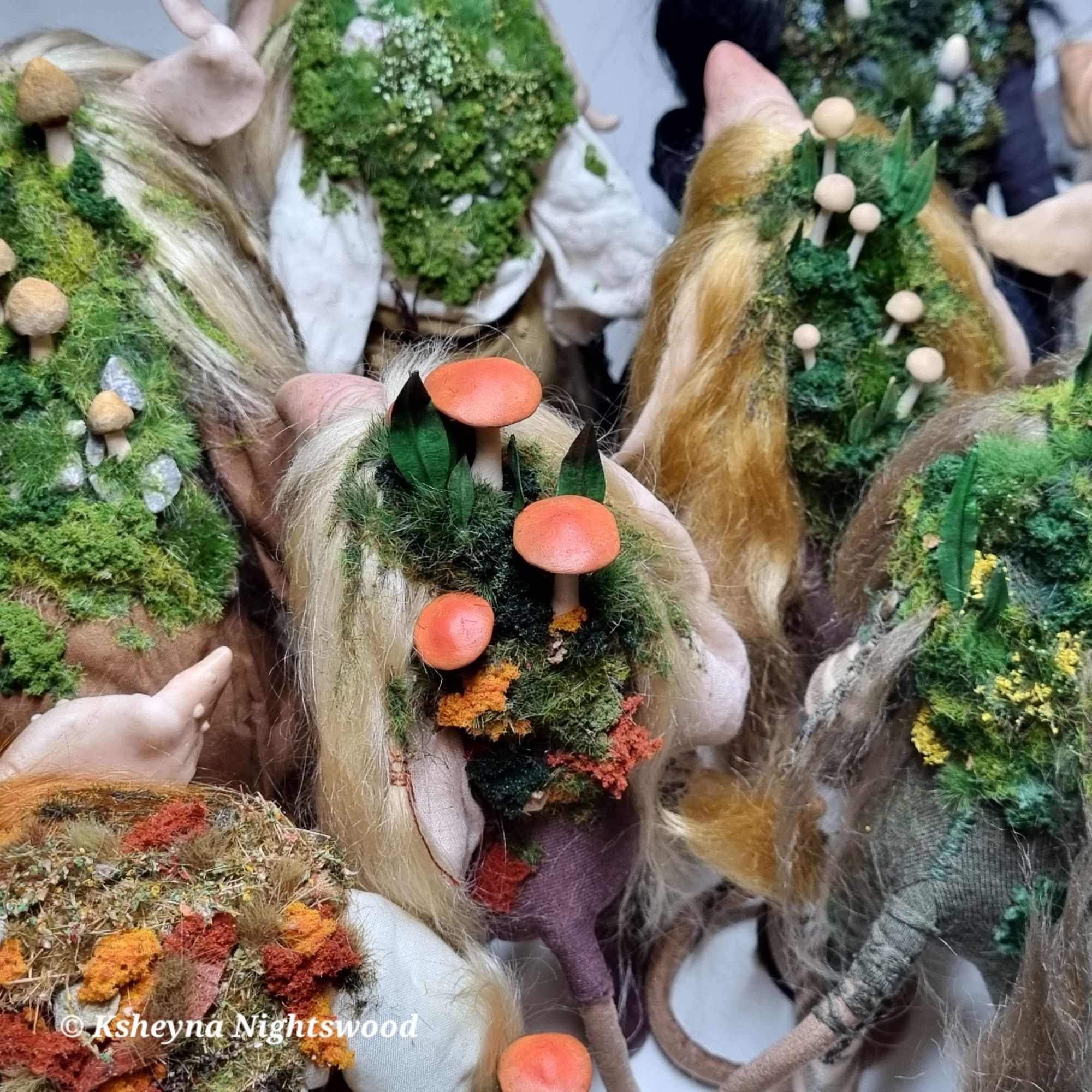 Moss and mushrooms covered backs of several (Scandinavian-inspired) troll art dolls.