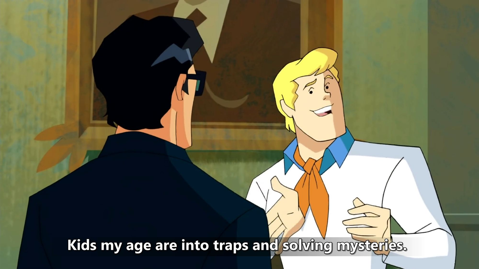 a screencap of Scooby Doo Mystery Incorporated with Fred (in a white shirt with blue collar and signature orange ascot tie) talking to a man in a black suit. The subtitle reads "Kids my age are into traps and solving mysteries."