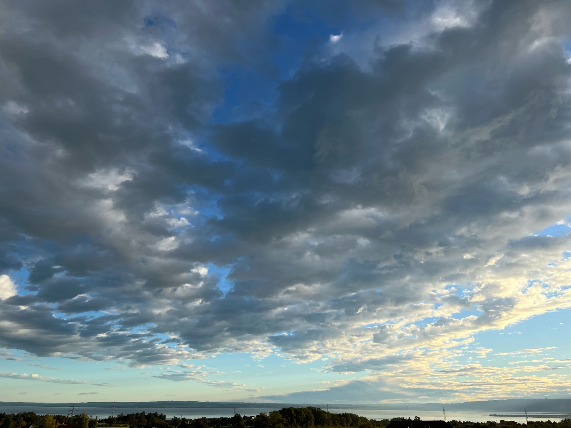 Grey and white puffy cloud blanket on a blue sky