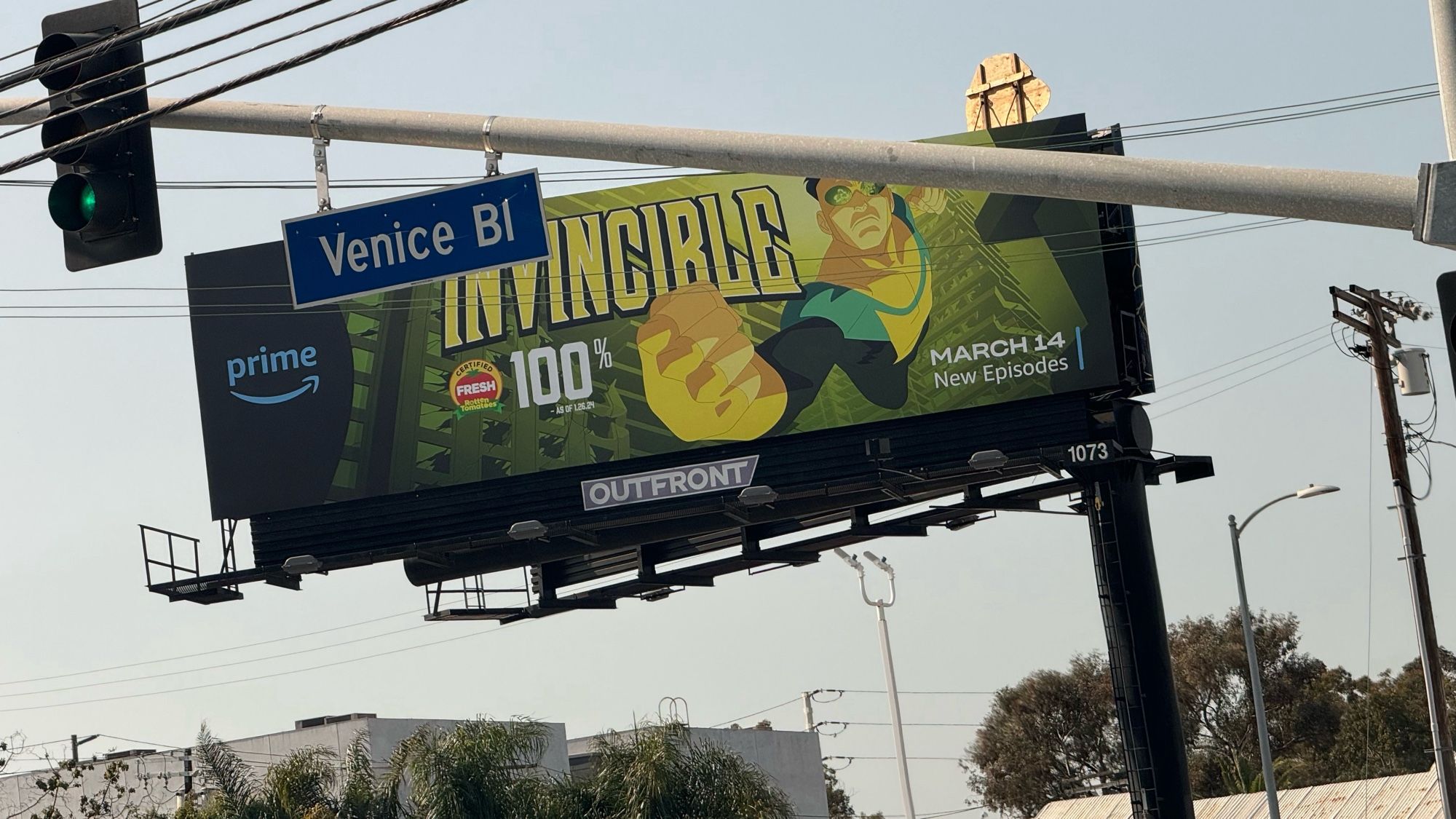 Antiquated large outdoor paper sign advertising the show INVINCIBLE featuring artwork by co-creator Cory Walker. Photo appears to be taken while driving. Oh dear that’s reckless.