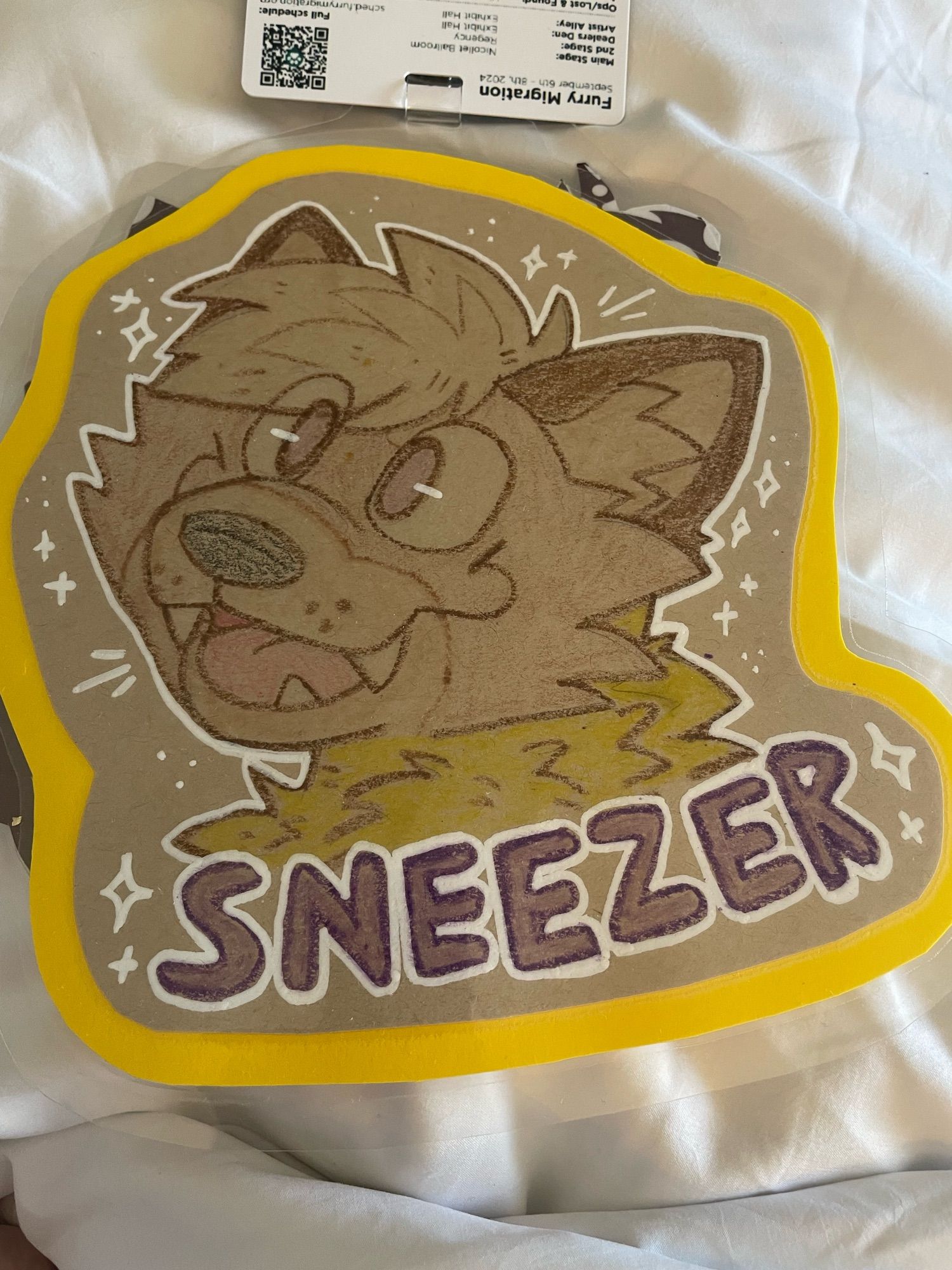 Picture of my pine marten character with a silly smile. The name “Sneezer” is at the bottom of the badge.