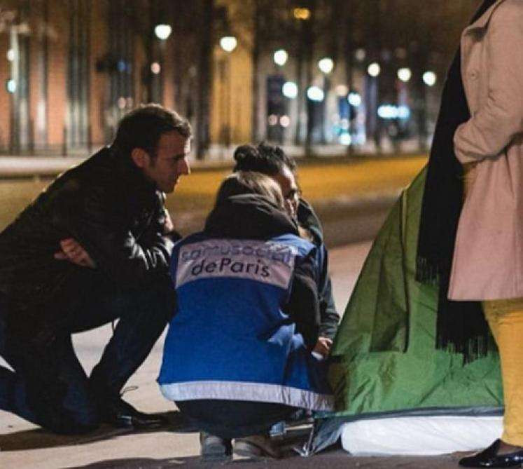 Emmanuel Macron parle à un SDF.
Emmanuel Macron talks to a homeless person.