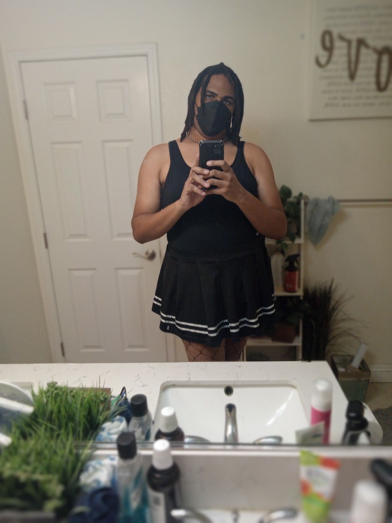 A selfie of OP wearing a spaghetti strap, mini skirt, and fishnet pantyhose