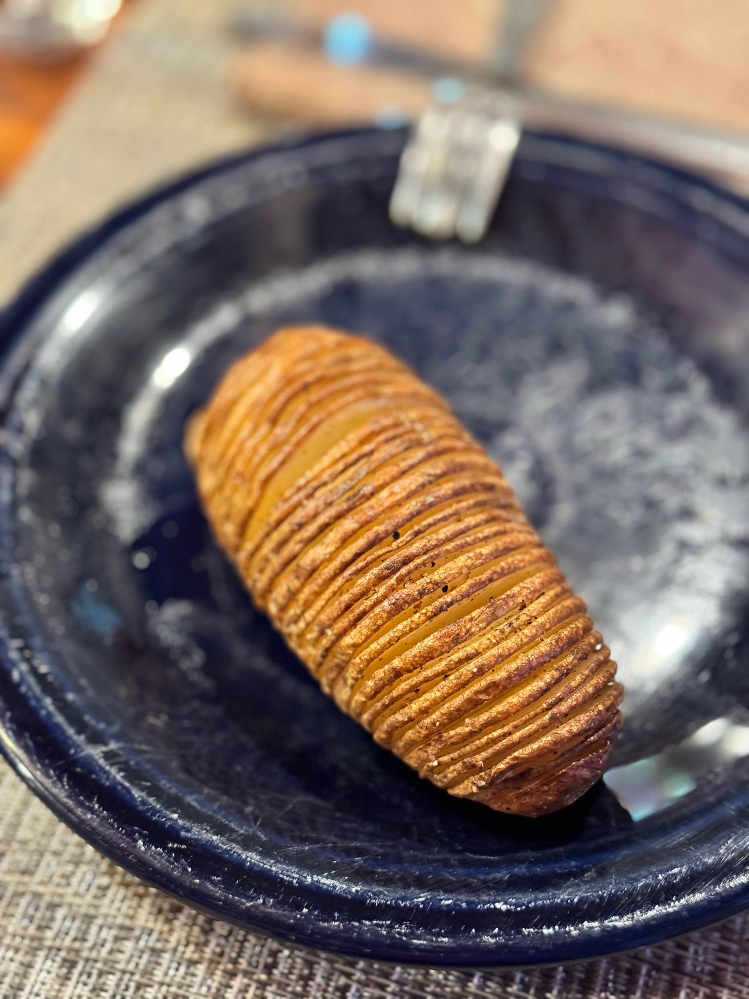 A baked potato. On a blue plate.