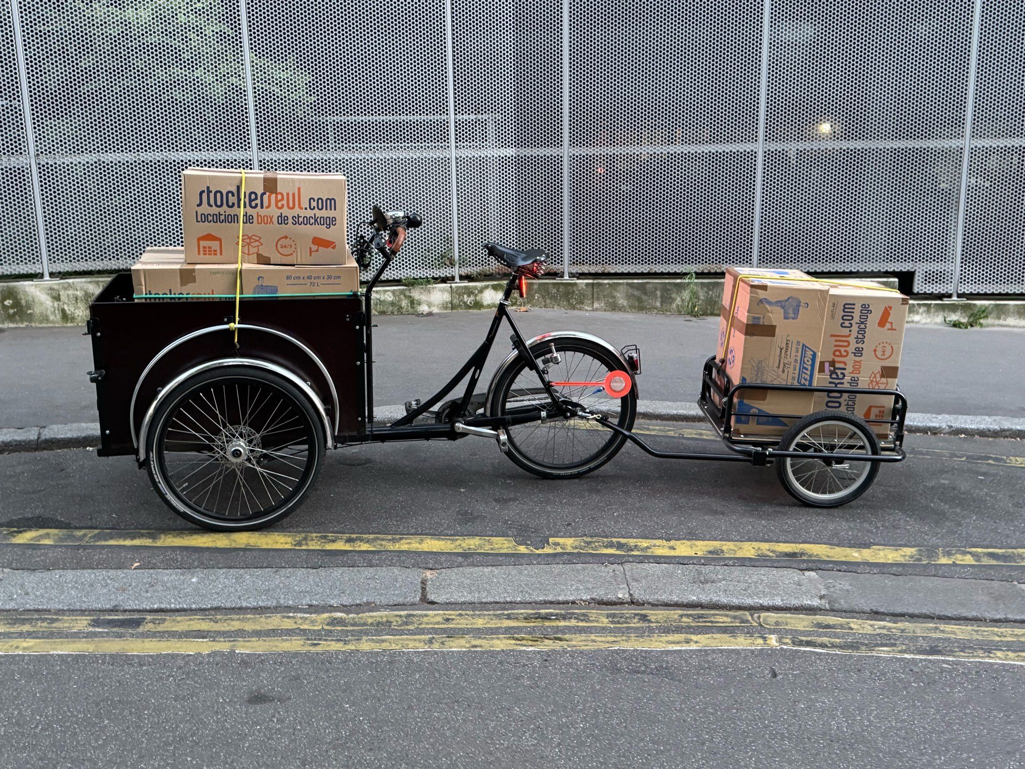 Vélo cargo et remorque pleins de cartons de déménagement.