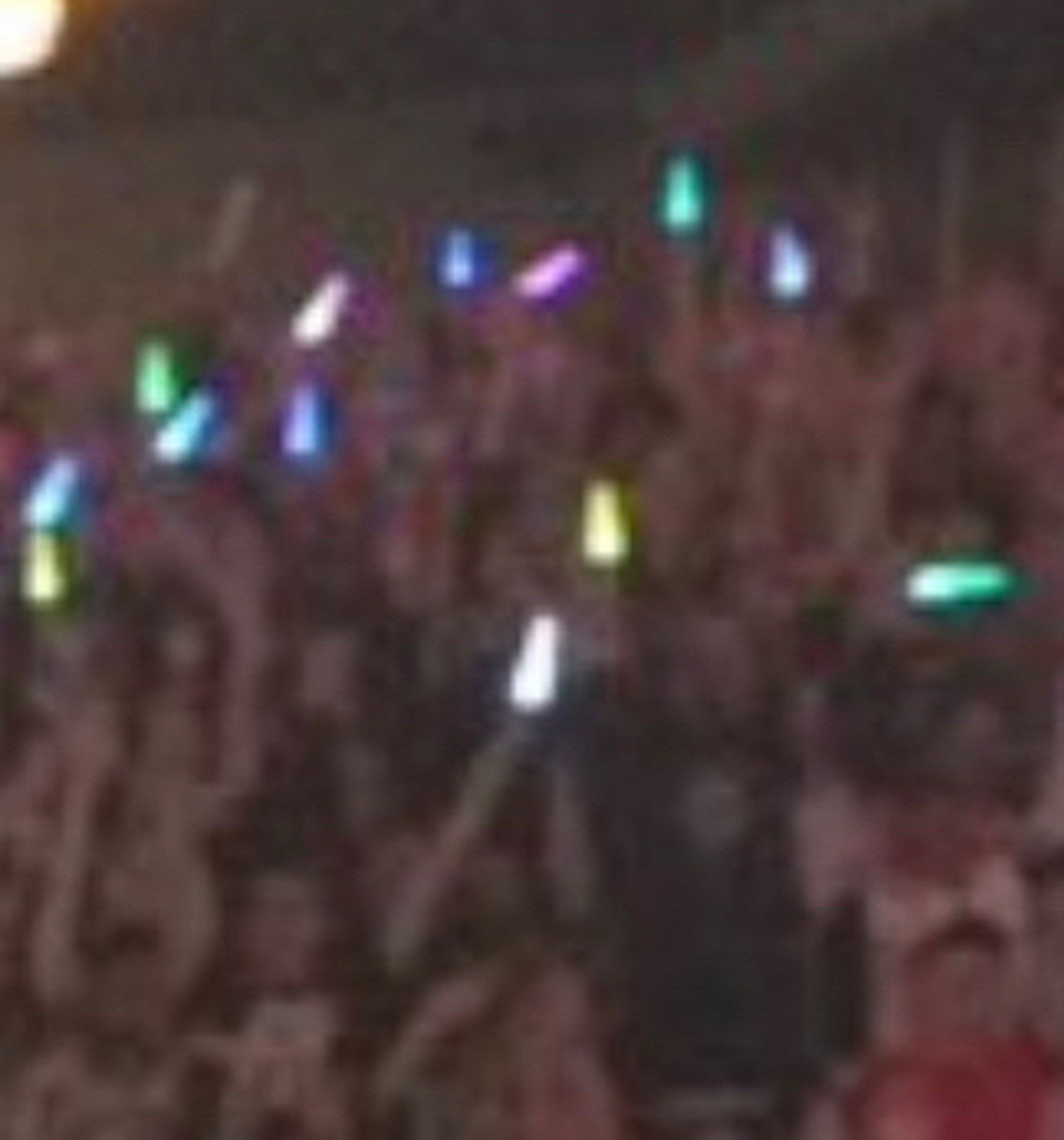 a very very very blurry screenshot of a section of the sonic symphony crowd. in the middle is a yellow light held by me!