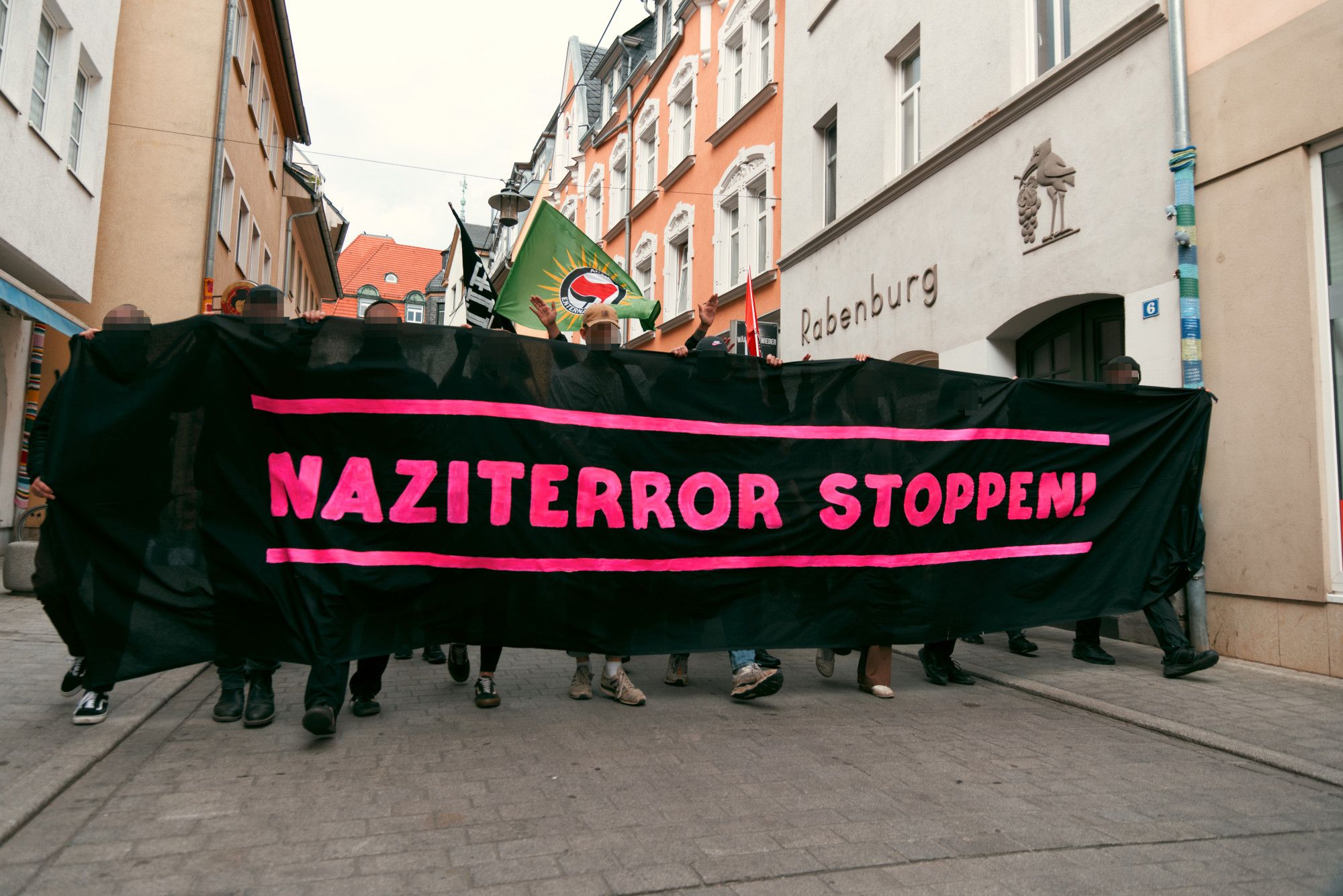 Schwarzes Fronttransparent der Demonstration mit pinker "Naziterror stoppen!" Aufschrift