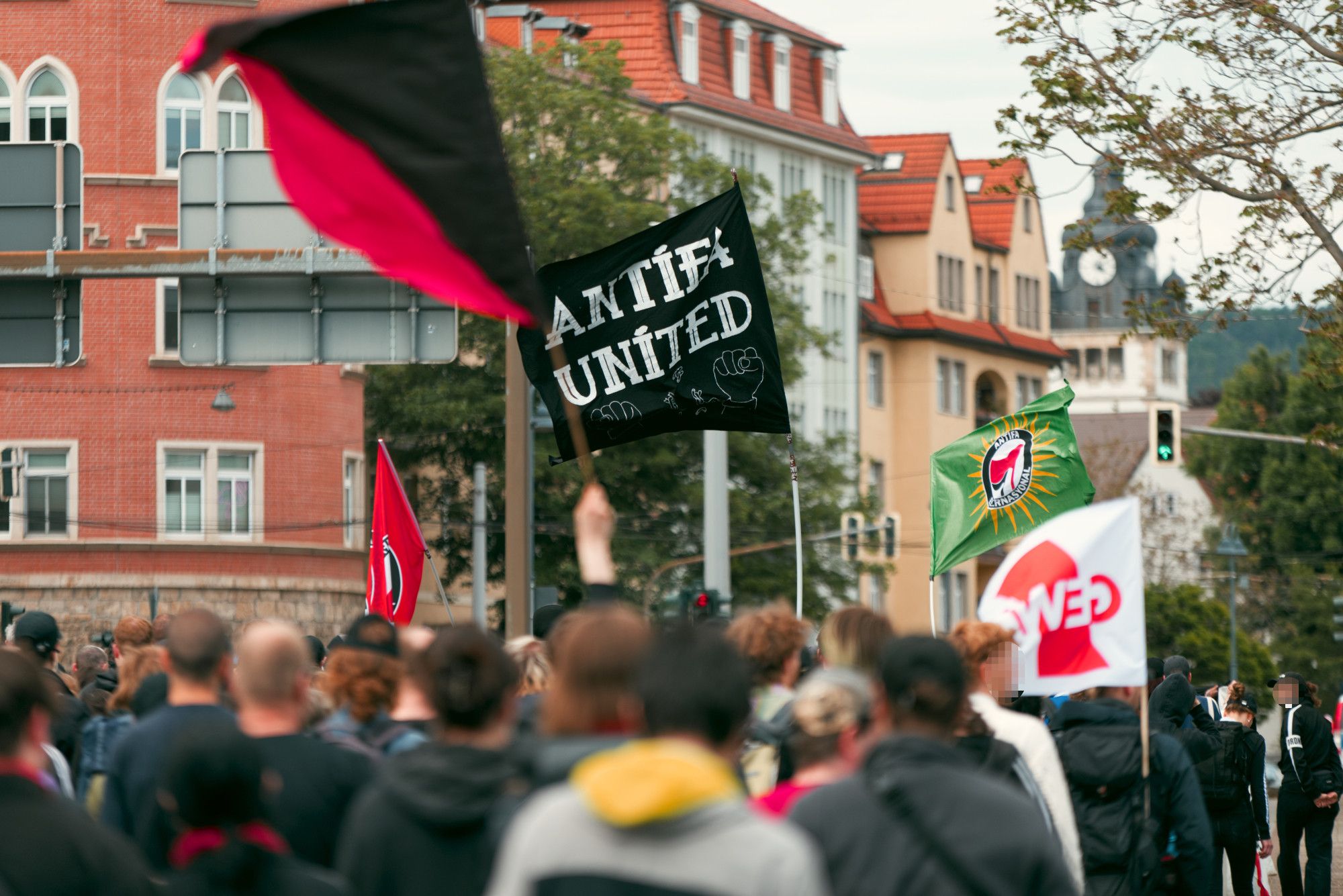 Rückansicht über die Demonstration hinweg. Mittig eine schwarze "Antifa united" Fahne