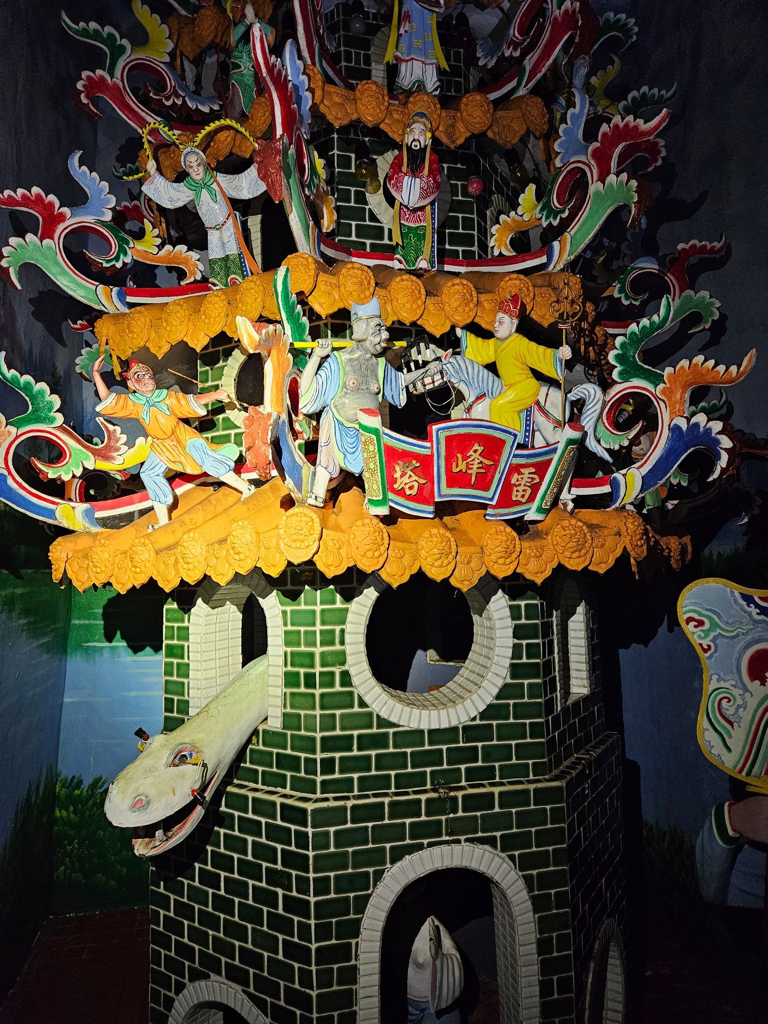 A miniature tower in an underground tunnel based on the Legend of the White Snake. The snake is looking out from a window on the second level. Some characters from Journey to the West appear on the roof of the tower.