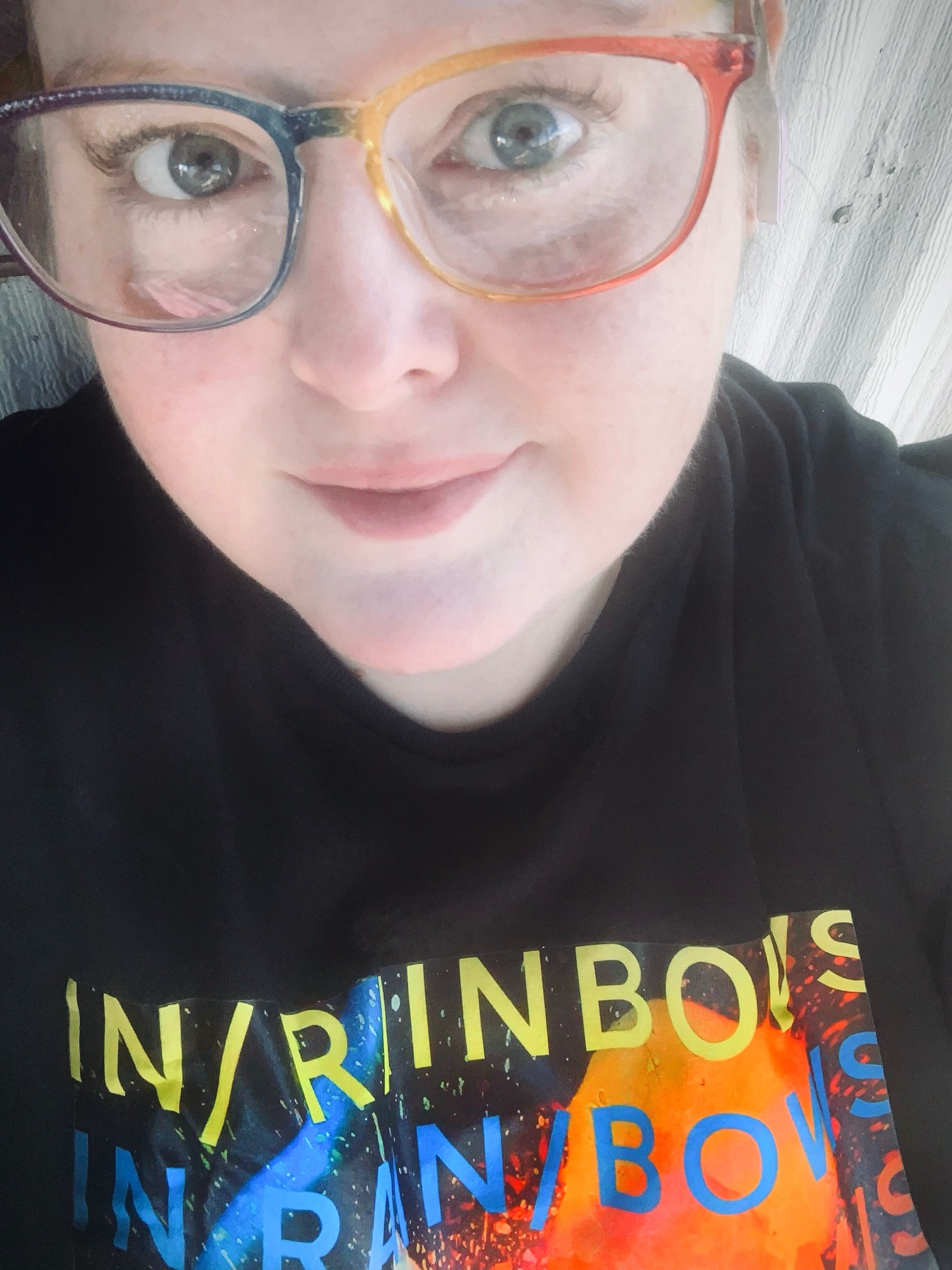 a selfie of juni wearing rainbow glasses and her janky radiohead in rainbows shirt 