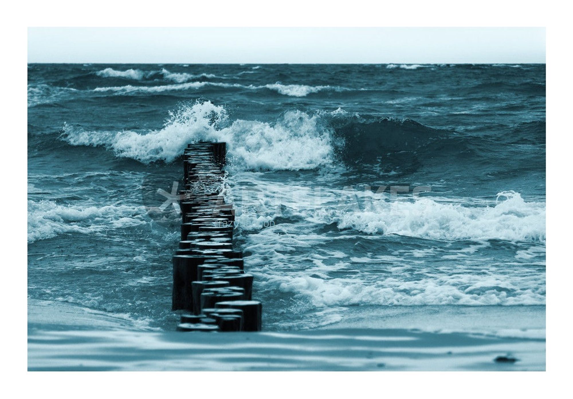 Fotografie, monochrom, Petrol-Taubenblau-Töne, Querformat, weißer Rand (Wasserzeichen: "* ARTFLAKES" und "crazyneopop")

Blick vom Strand auf senkrecht ins Meer ragende, dunkle Buhnenim linken Bildteil, an denen einige hohe, weiß schäumenden Wellen branden. Am unterne Bildrand: der von zurückweichenden Wellen umspülte Sand. Am Oberen Bildrand: der Horizont mit einem schmalen Streifen blassblauen Himmels,