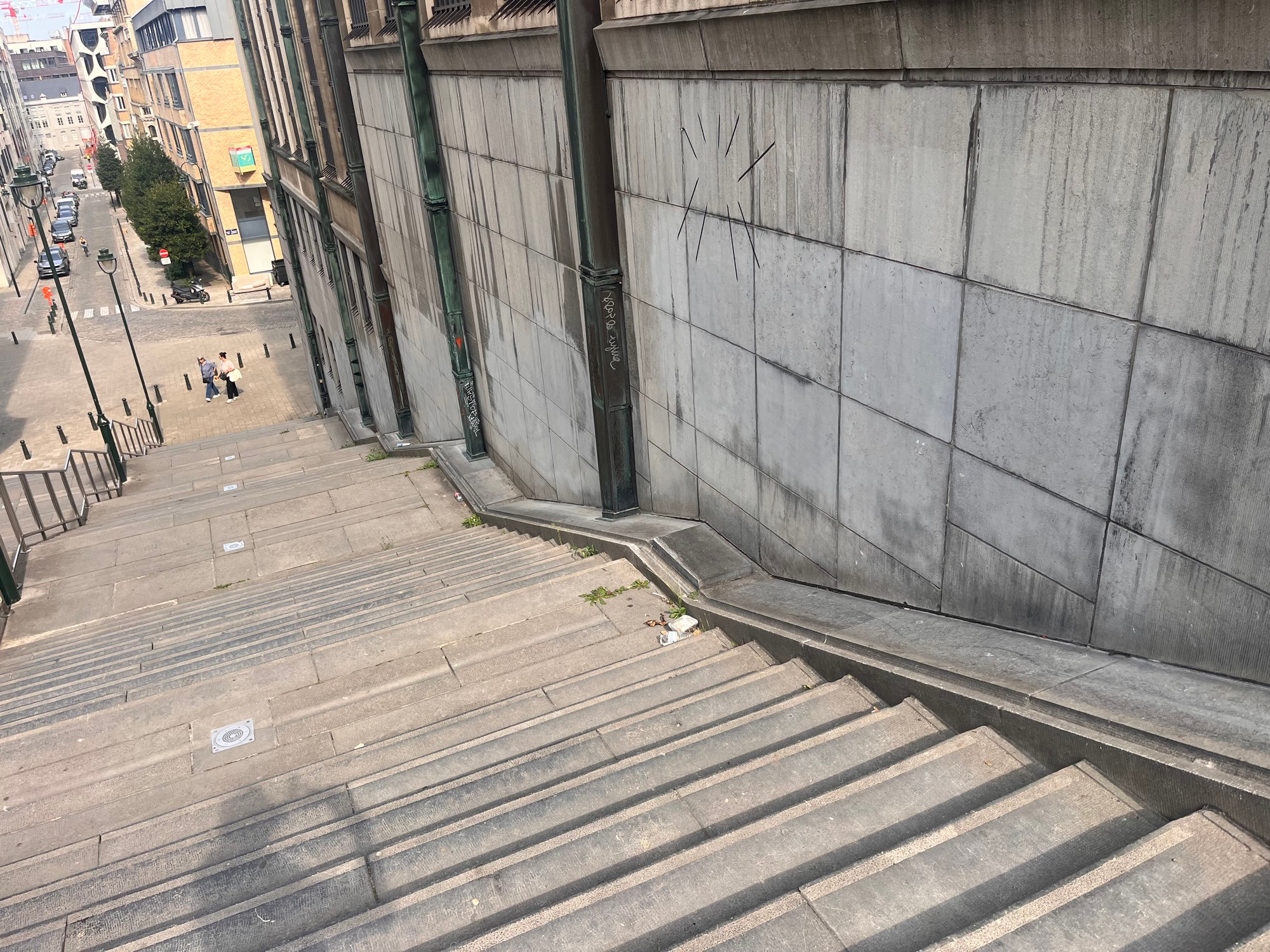 A looooong set of wise granite stairs connecting one street to another with a place to roll a bike alongside them