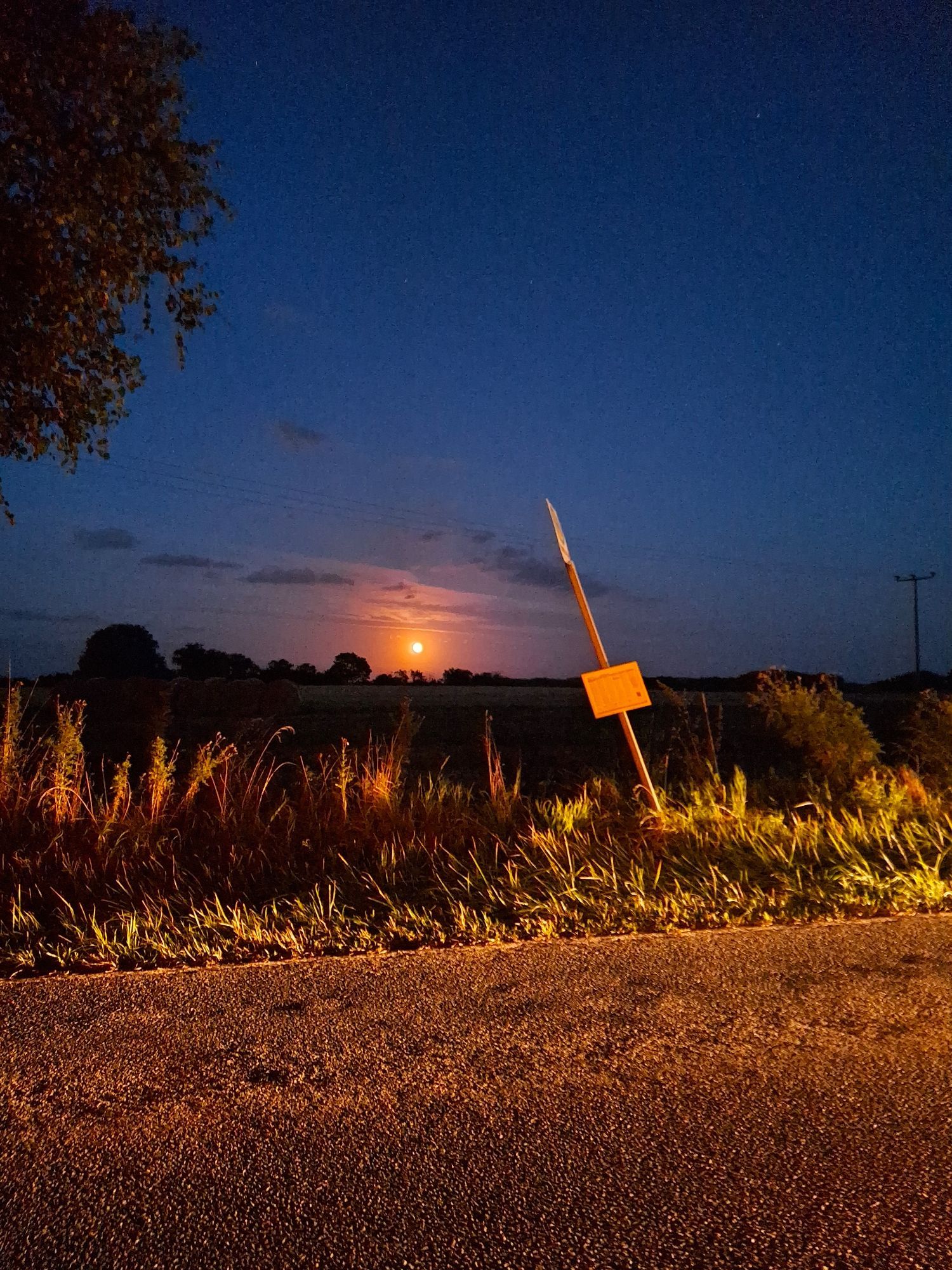 Bushaltestellen, mit Mond im Hintergrund und herannahendem Auto