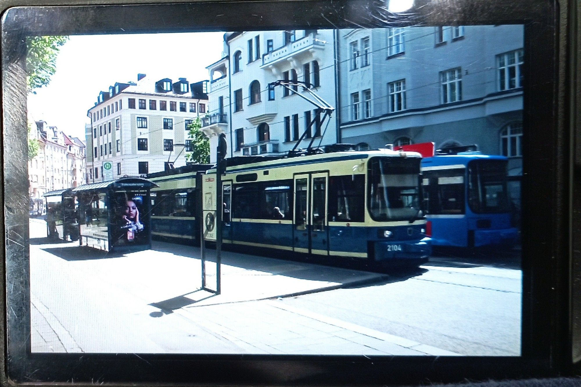 Blick auf Kameradisplay. Zu sehen ist Tram Alt-R2 2104 auf Linie 12 Richtung Amalienburgstraße am Hohenzollernplatz an der Haltestelle.