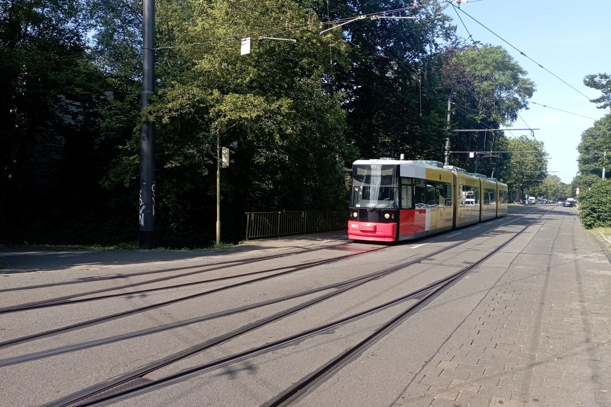 Vierteiliger GT8N mit rot-schwarzer Front und gelber Werbung an der Einfahrt zum Betriebshof Neue Vahr-Süd.