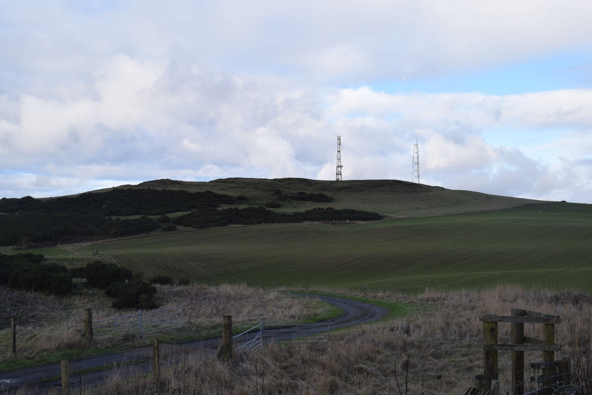 View of Down Law hillfort from the south, looking north showing the fort in the midground with the phone masts behind.