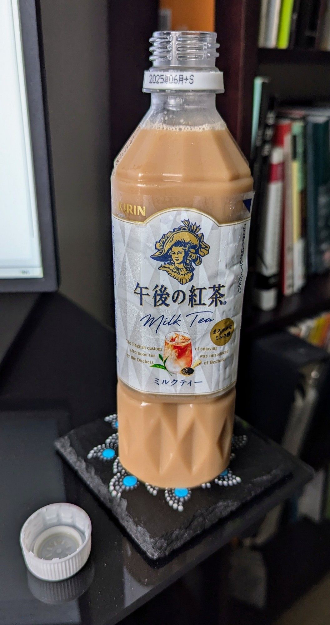 A bottle of Kirin's milk tea imported from Japan.

Ojika and I got mildly hooked on this stuff during our trip to Japan. It's a cheap offering in most convenience stores and some vending machines that really hit the spot on the hot days.

Japanese marketing often ignores English sentence/word layout in favor of looking fancy with a bit of foreign language on their packaging. The label reads, "The English custom of enjoying afternoon tea was introduced by the Duchess of Bedford." However, because they jammed a picture in the middle of the sentence, it instead looks like it reads as, "The English custom afternoon tea by the Duchess of enjoying was introduced of Bedford.

So we've taken to thanking the Duchess of Enjoying for her delightful tea.