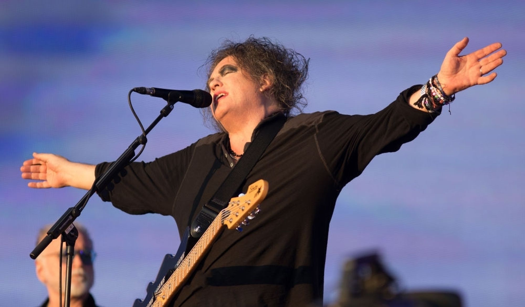 Robert Smith hält die Arme zur Umarmung offen.