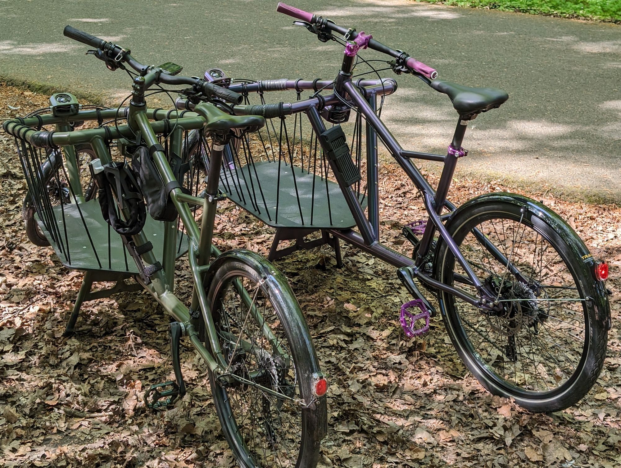 Zwei Lastenräder Cargobikemonkey Radlader von Traix.de in freier Wildbahn. Links der oliverLader in RAL6031 bronzegrün, rechts das Fahrrad, das ich nicht PornoLader nennen darf. Flipfloplack von grau zu lila über dunkelgrün.