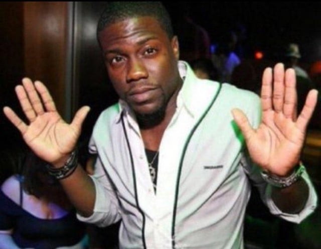 Kevin Hart looking goofy while he puts his hands up.