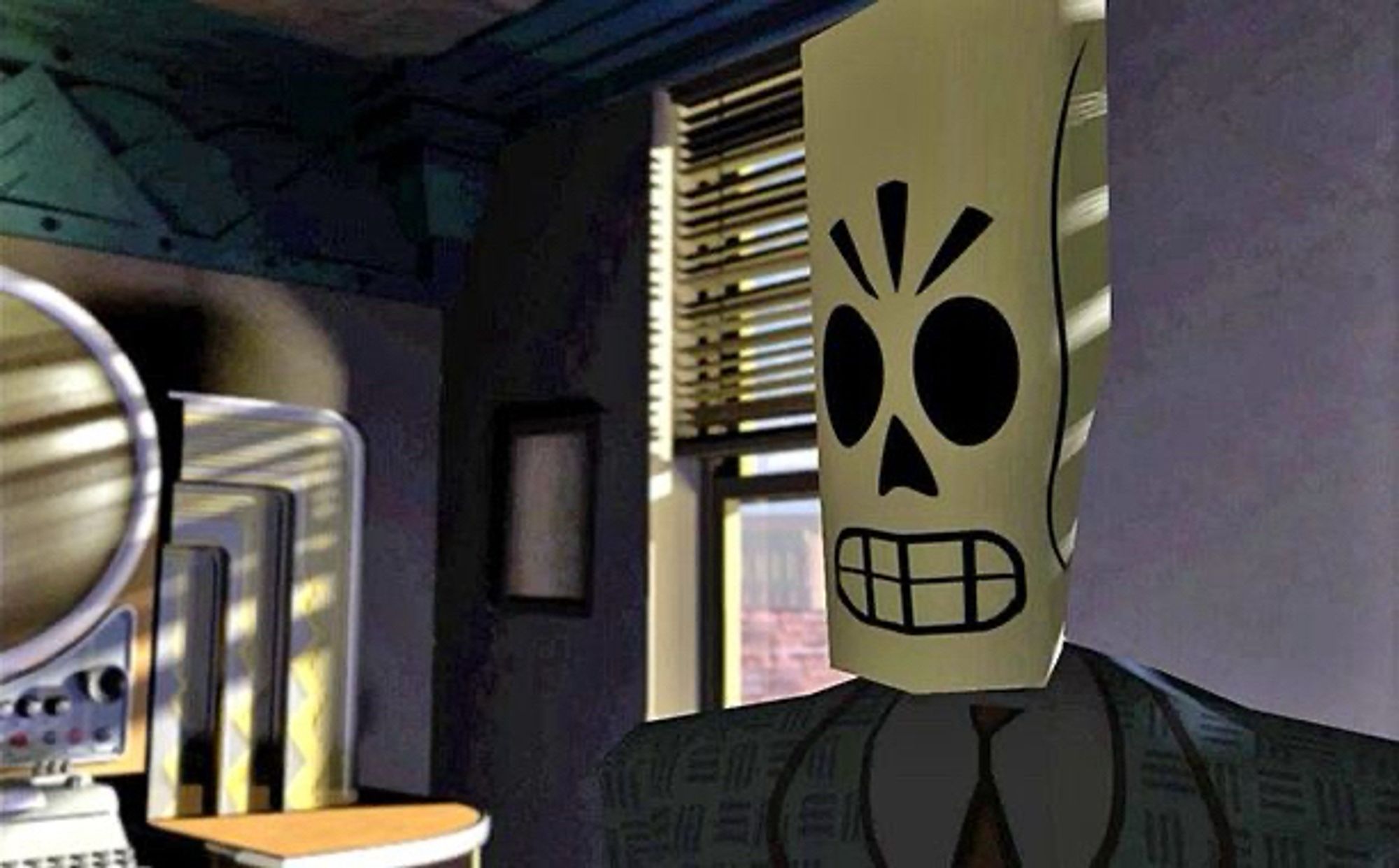 Manny Calavera from Grim Fandango standing in his office, close up, next to his computer and window to the right