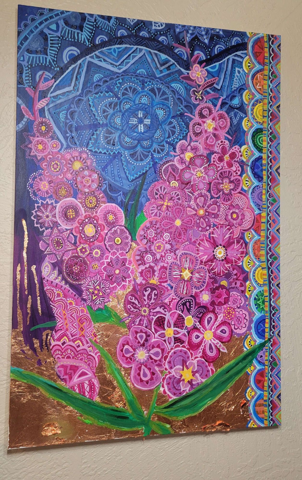 A large canvas on a wall of abstract, mandala-esque magenta fireweed flowers