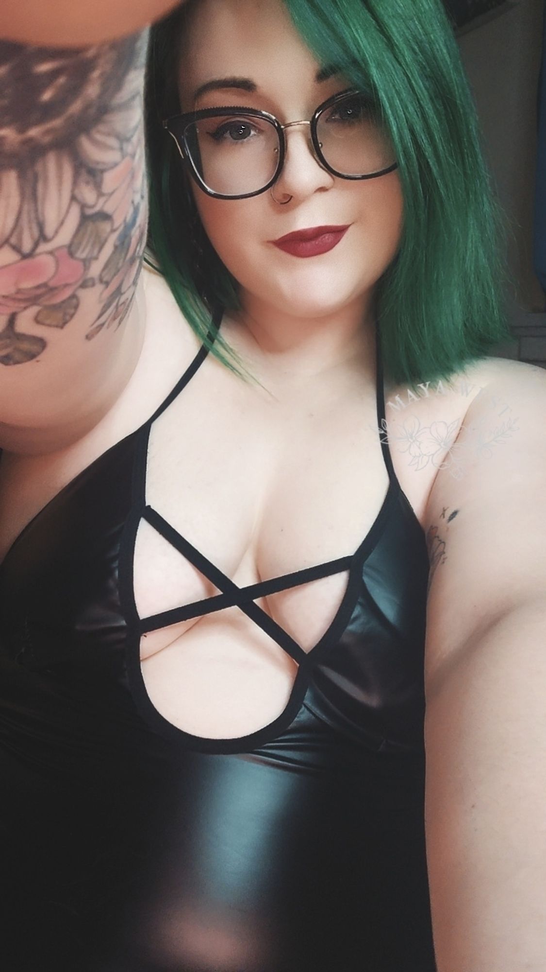 selfie of a pale, tattooed, and curvy femme with bright green hair in a black pleather dress.


🧡🖤🧡 
#bbw 
#milf