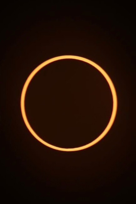 A perfect light golden ring (the Sun nearly completely eclipsed by the Moon) on a black background.