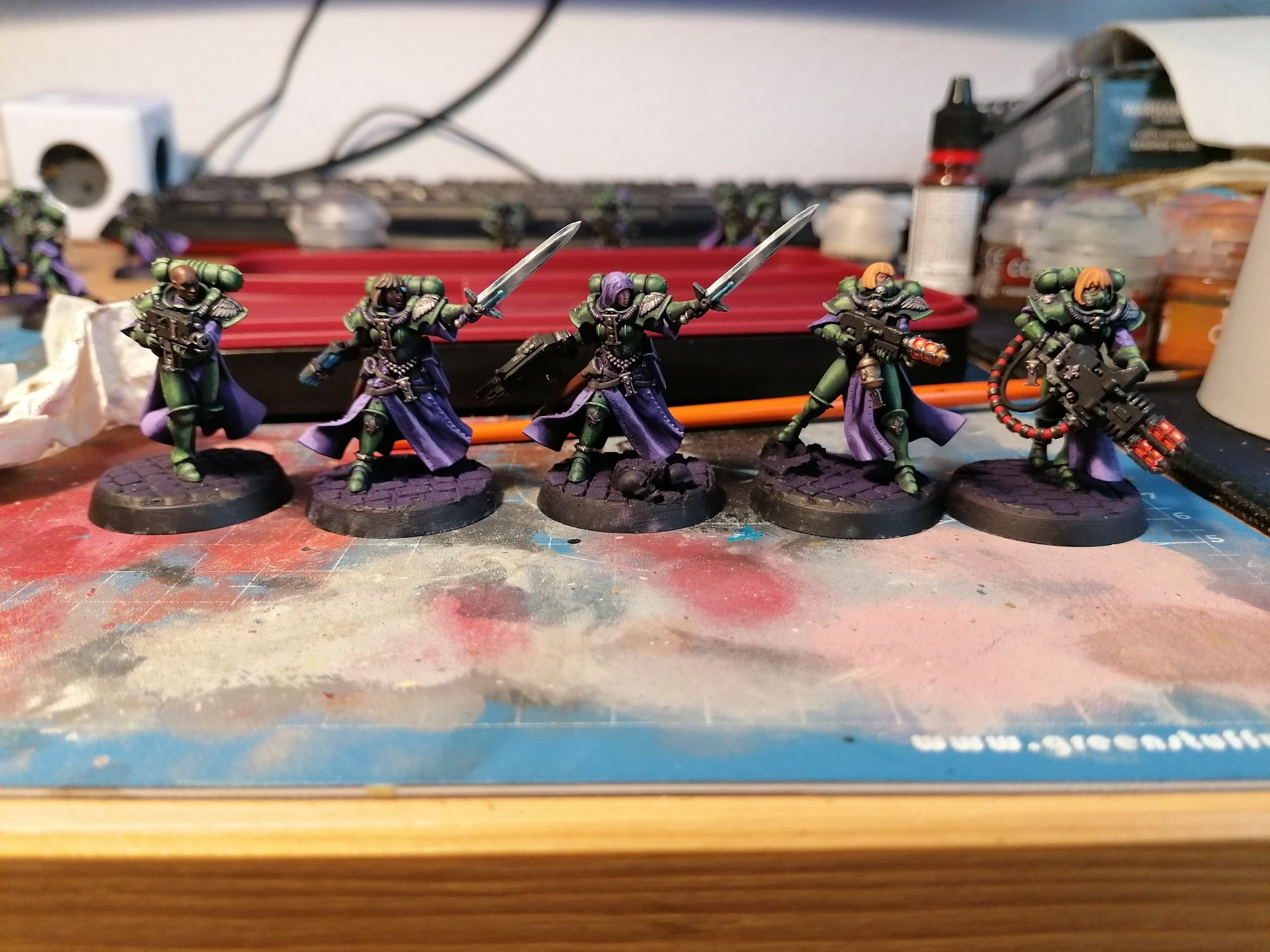 5 adepta sororitas battle sister minis for warhammer 40k, painted with green armor and purple capes