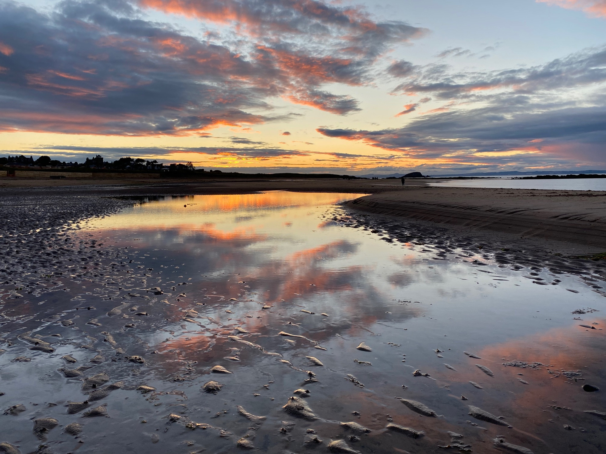 Sunset in North Berwick - September this year. A wet sandy beach with the water meandering across the beach into the distance and the sea to the right. The sky reflects on the beach