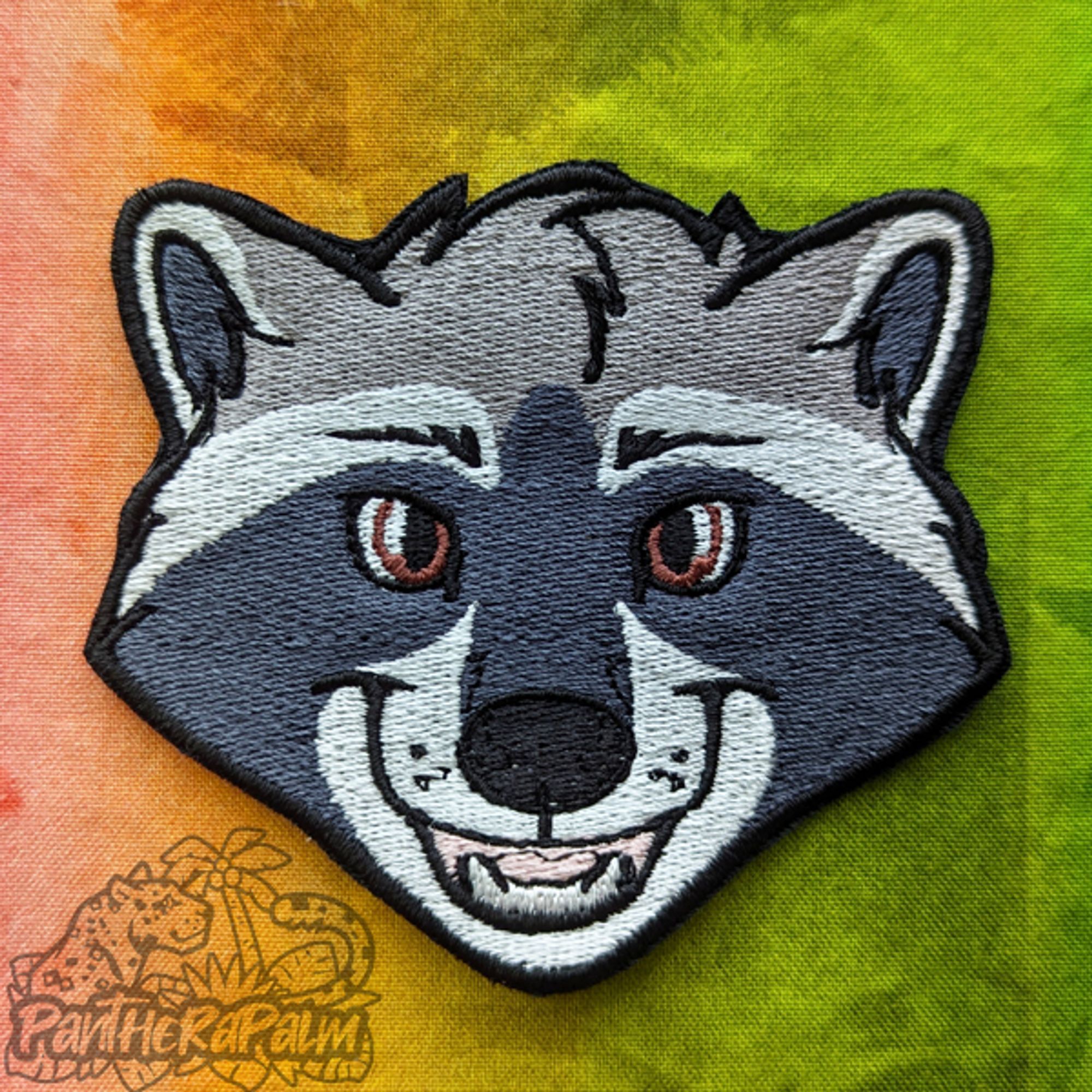 Raccoon face embroidered patch.