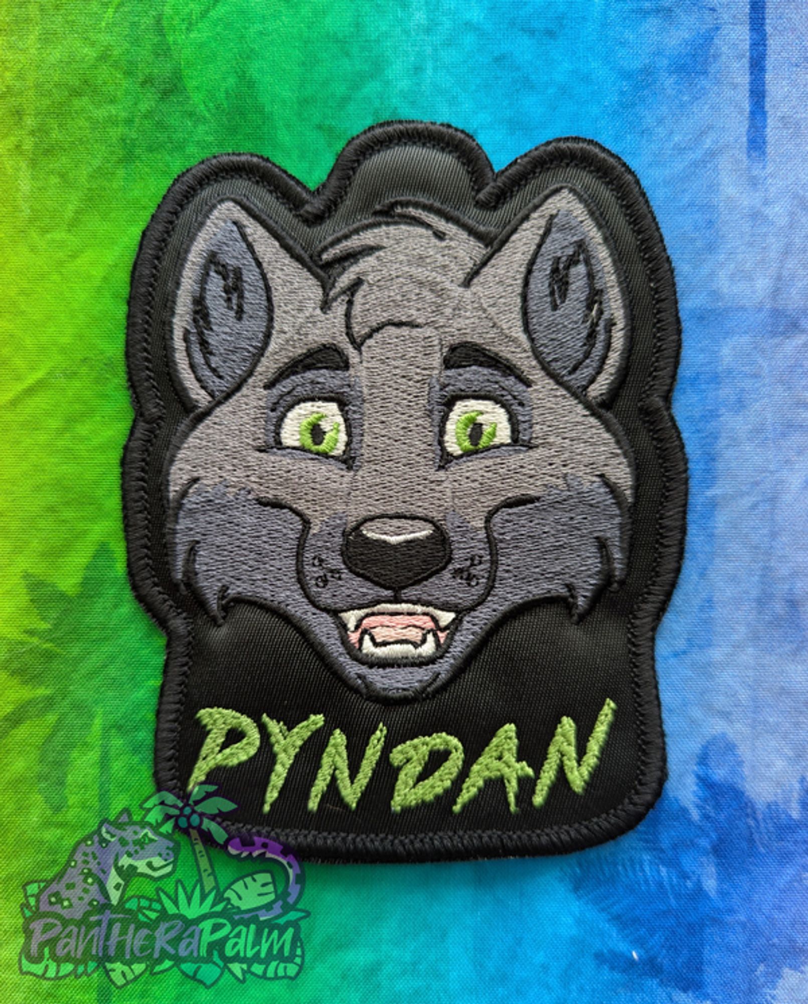 Grey wolf embroidered badge with the name Pyndan in green