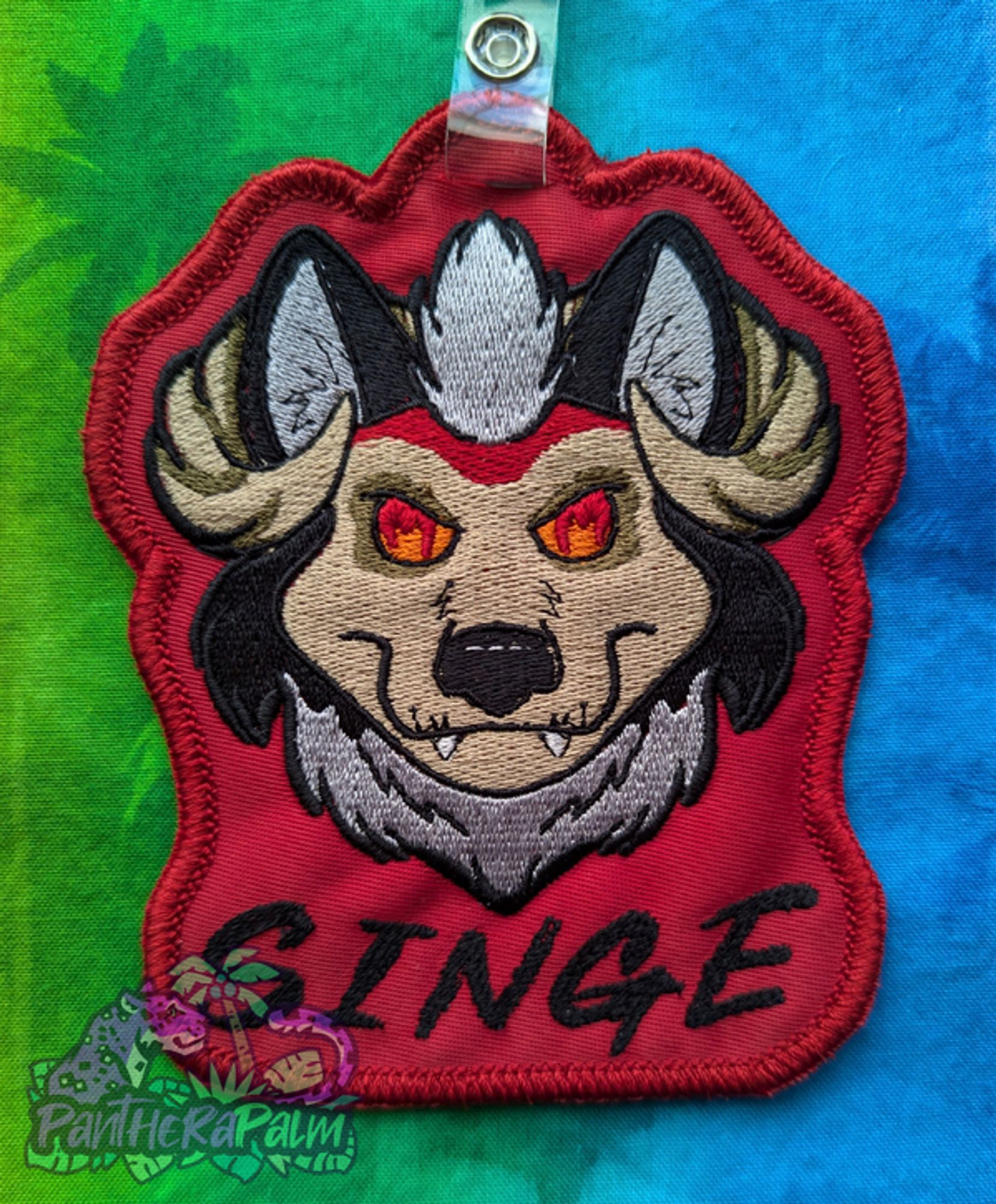 Embroidered red conbadge of hellhound character with the name Singe