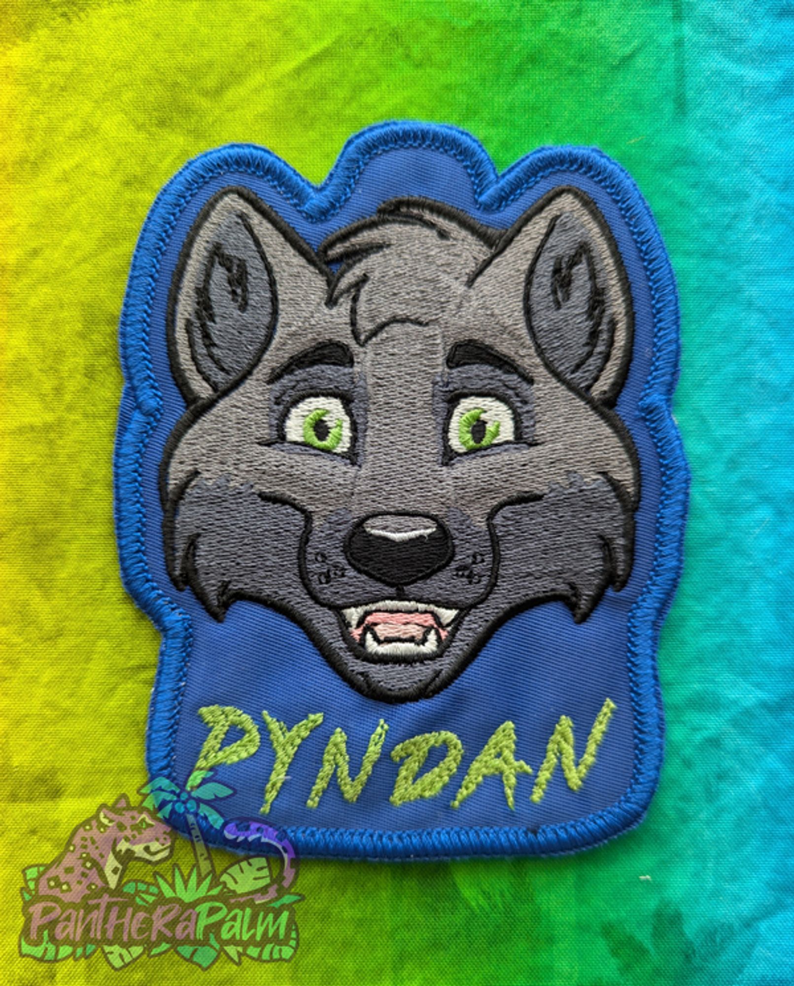 Grey wolf embroidered badge with the name Pyndan in green