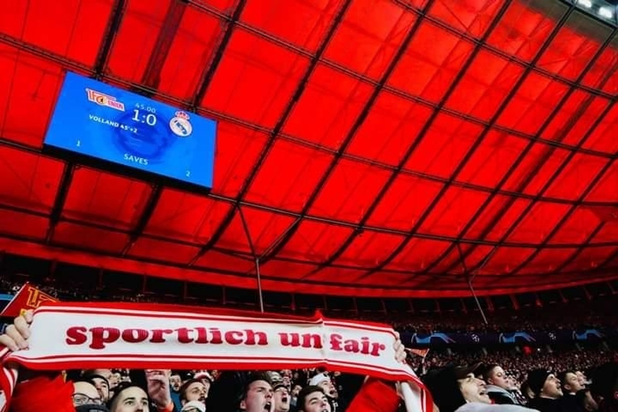 Anzeigetafel mit Zwischenergebnis: 1:0 für Union. 
Davor der Sportlich und Fair- Schal, verkürzt zu sportlich unfair.