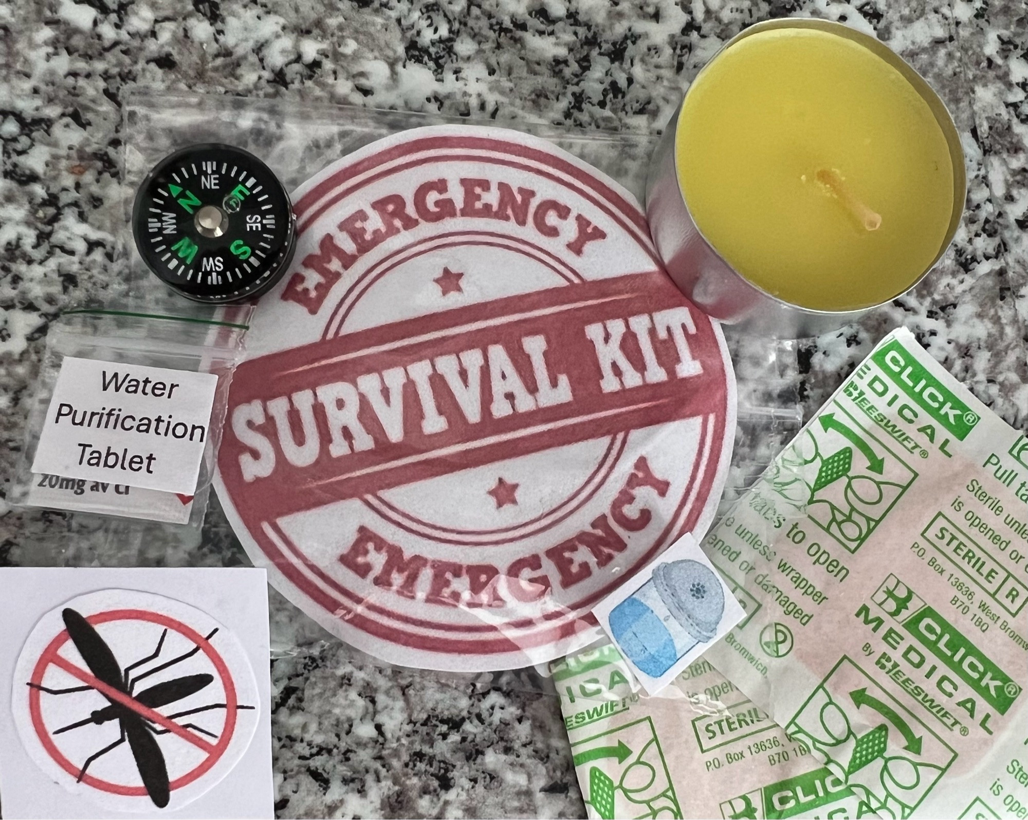 Bug sticker, water purification tablet, tiny compass, yellow tea light, 2 plasters and a survival kit sticker.