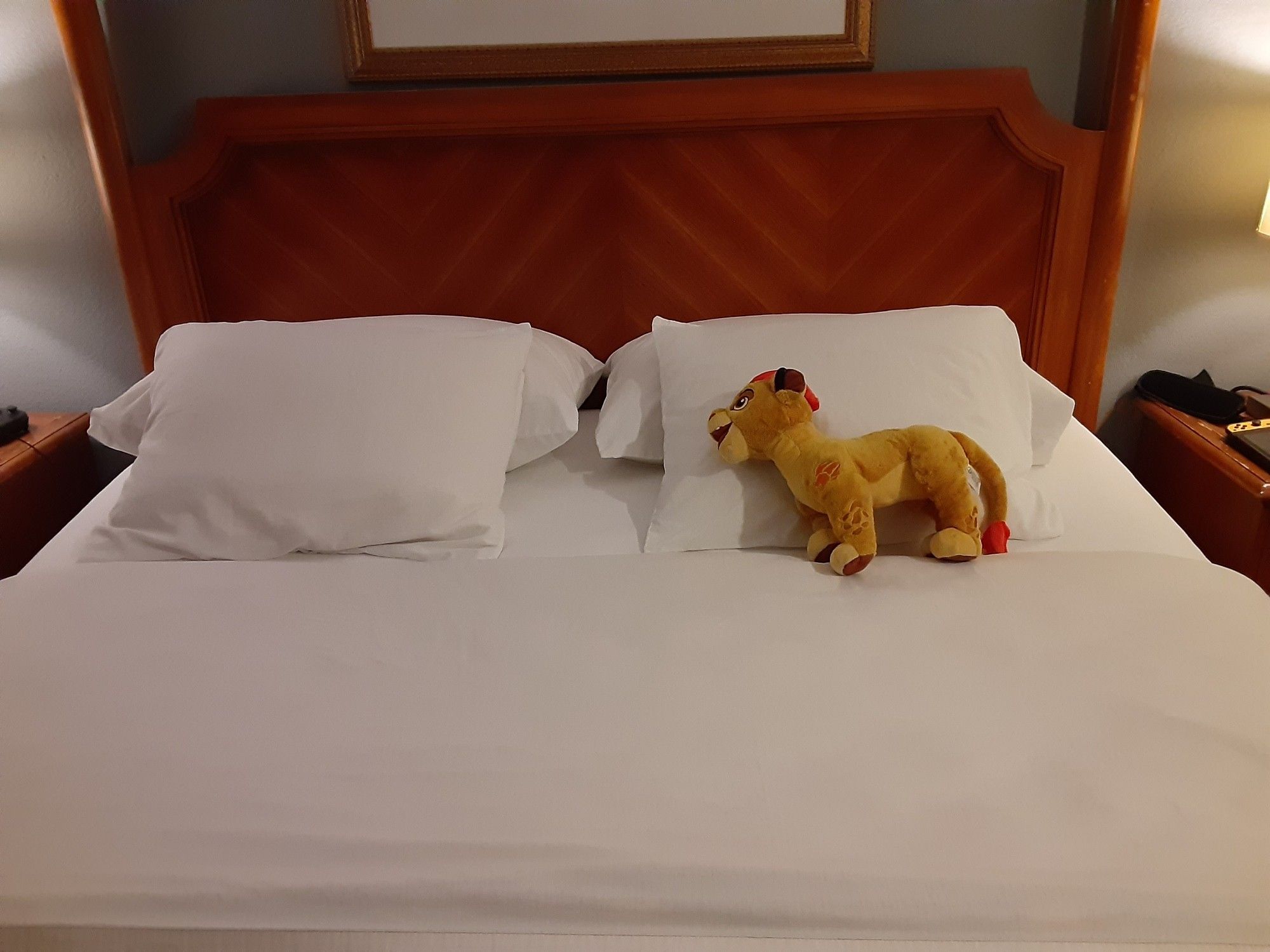 king size bed with Kion plushie by the pillows