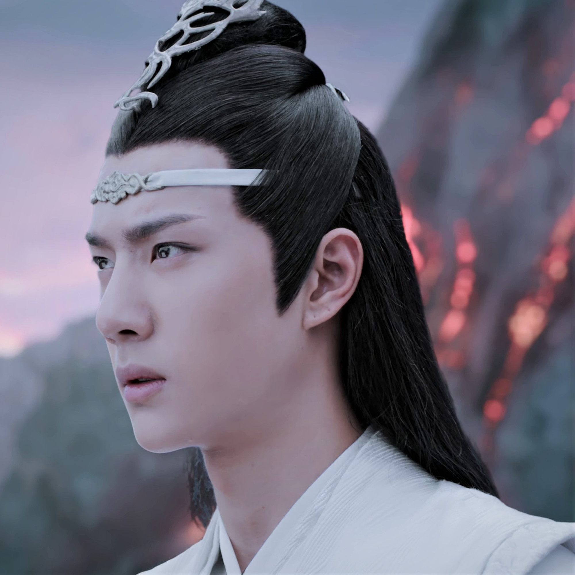 Close-up of a distraught Lan Wangji with Nightless City's active volcano in the background.