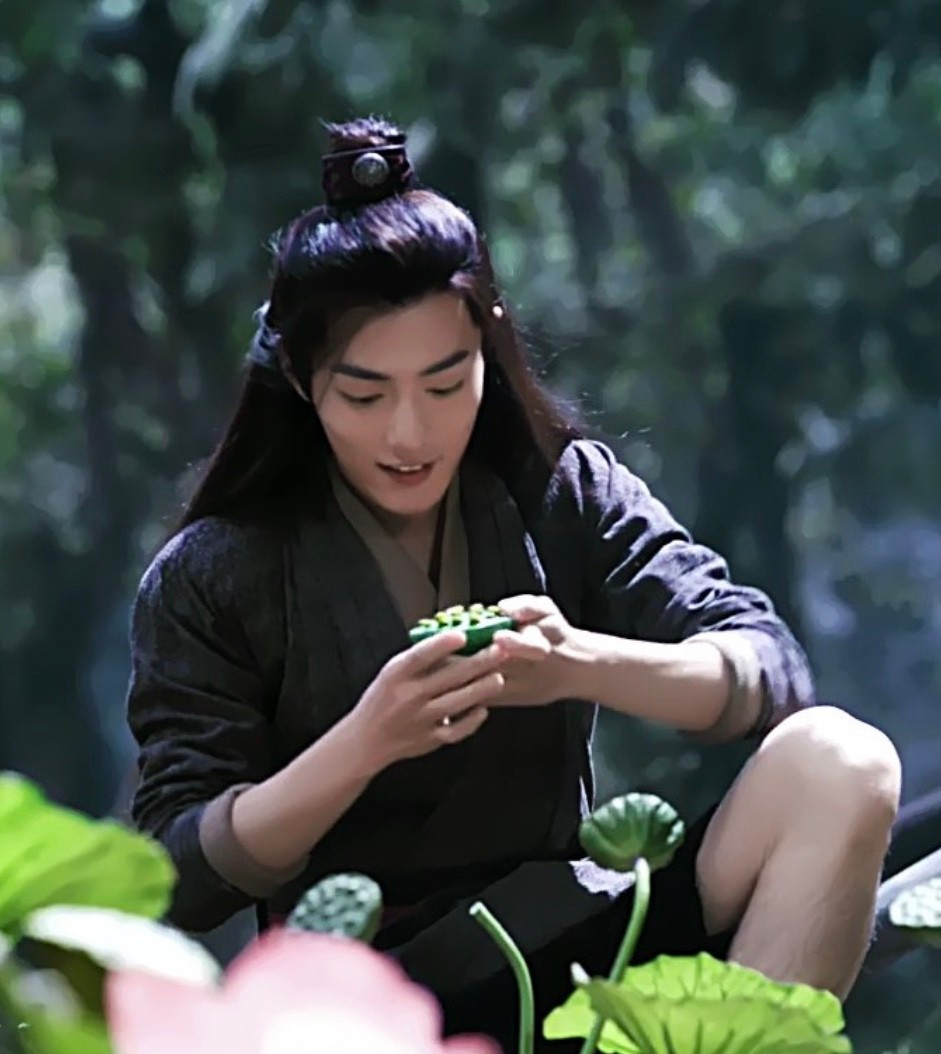 Happy lotus farmer Wei Wuxian, robes hiked up to his thighs, examines his lotus seed crop.