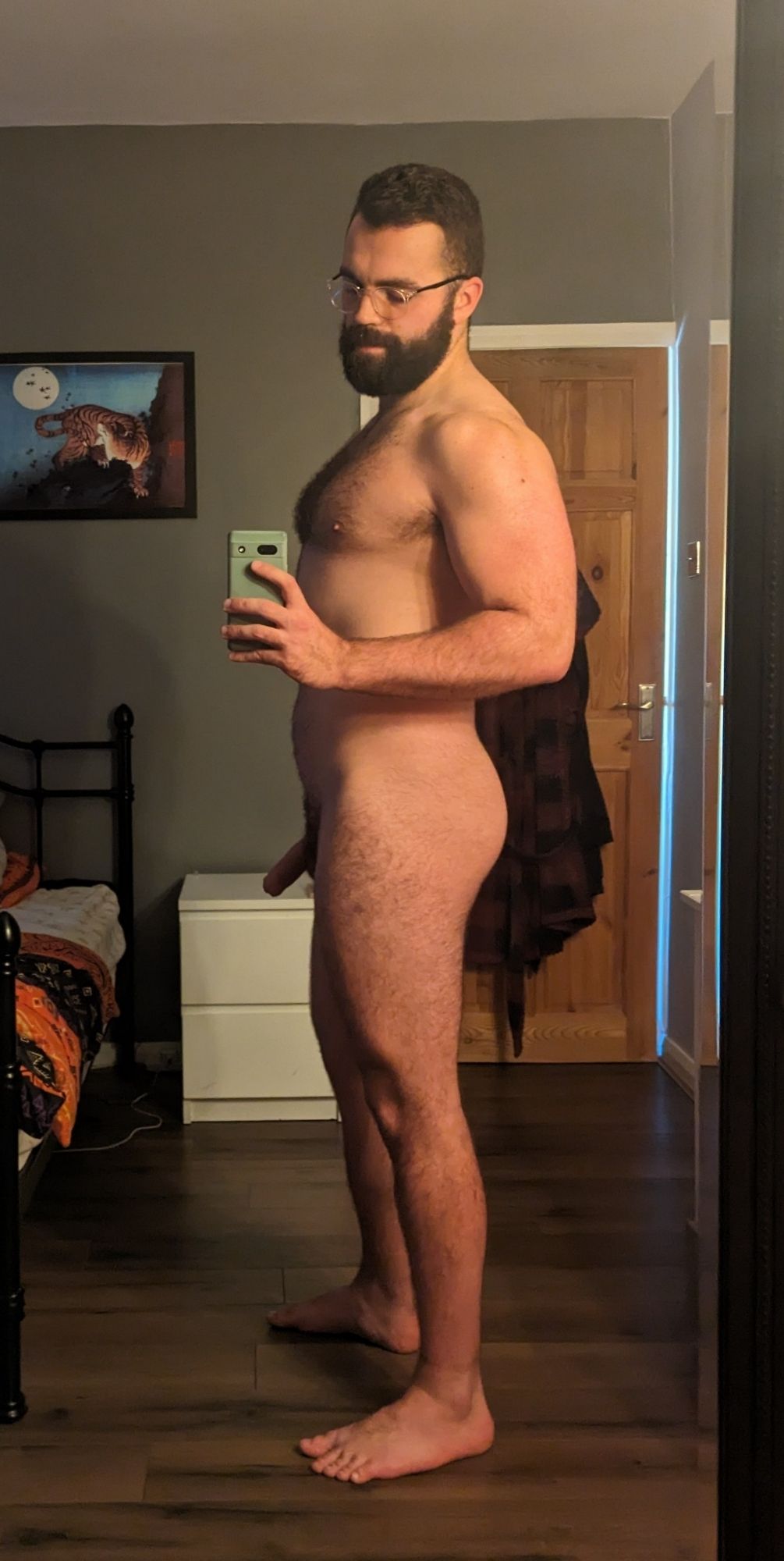 A side shot of me standing in the bedroom, naked.