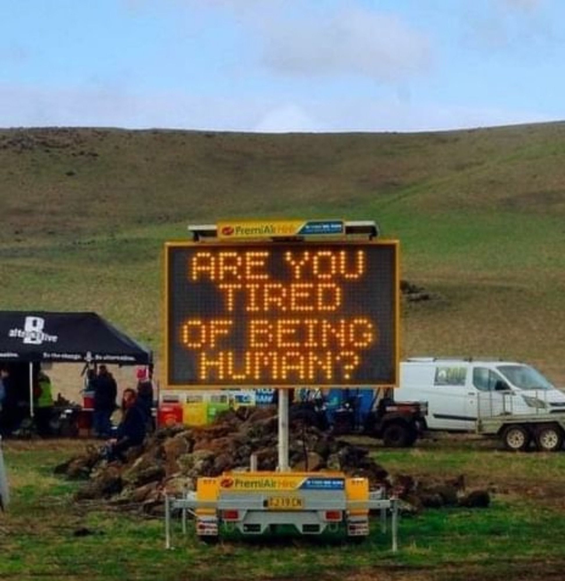 A billboard asks: Are You Tired of Being Human?