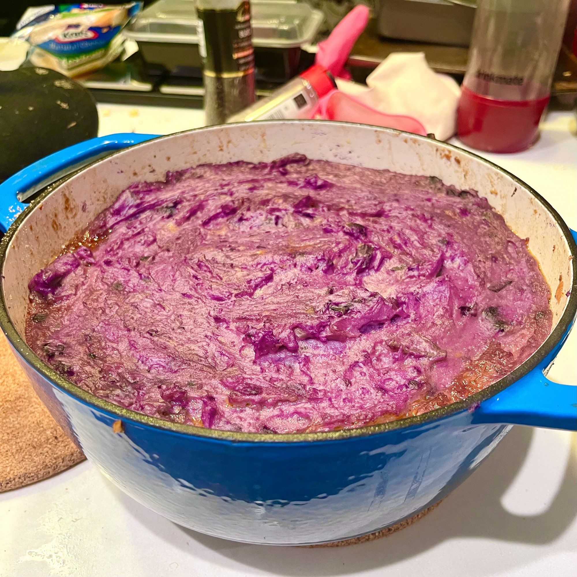 dutch oven sitting on a counter filled with purple mashed potatoes