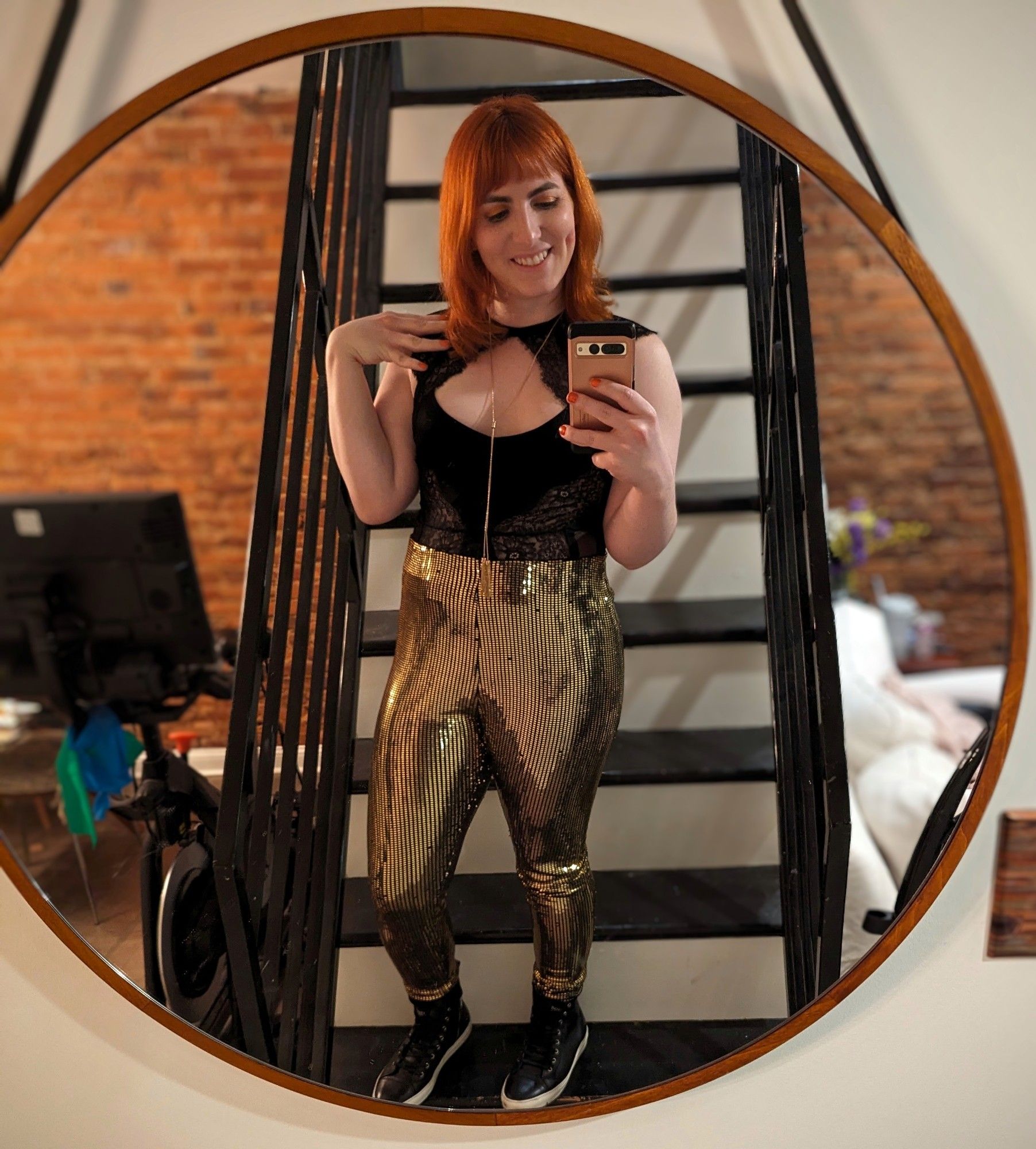 Kyra in a mirror with her gold disco pants and top