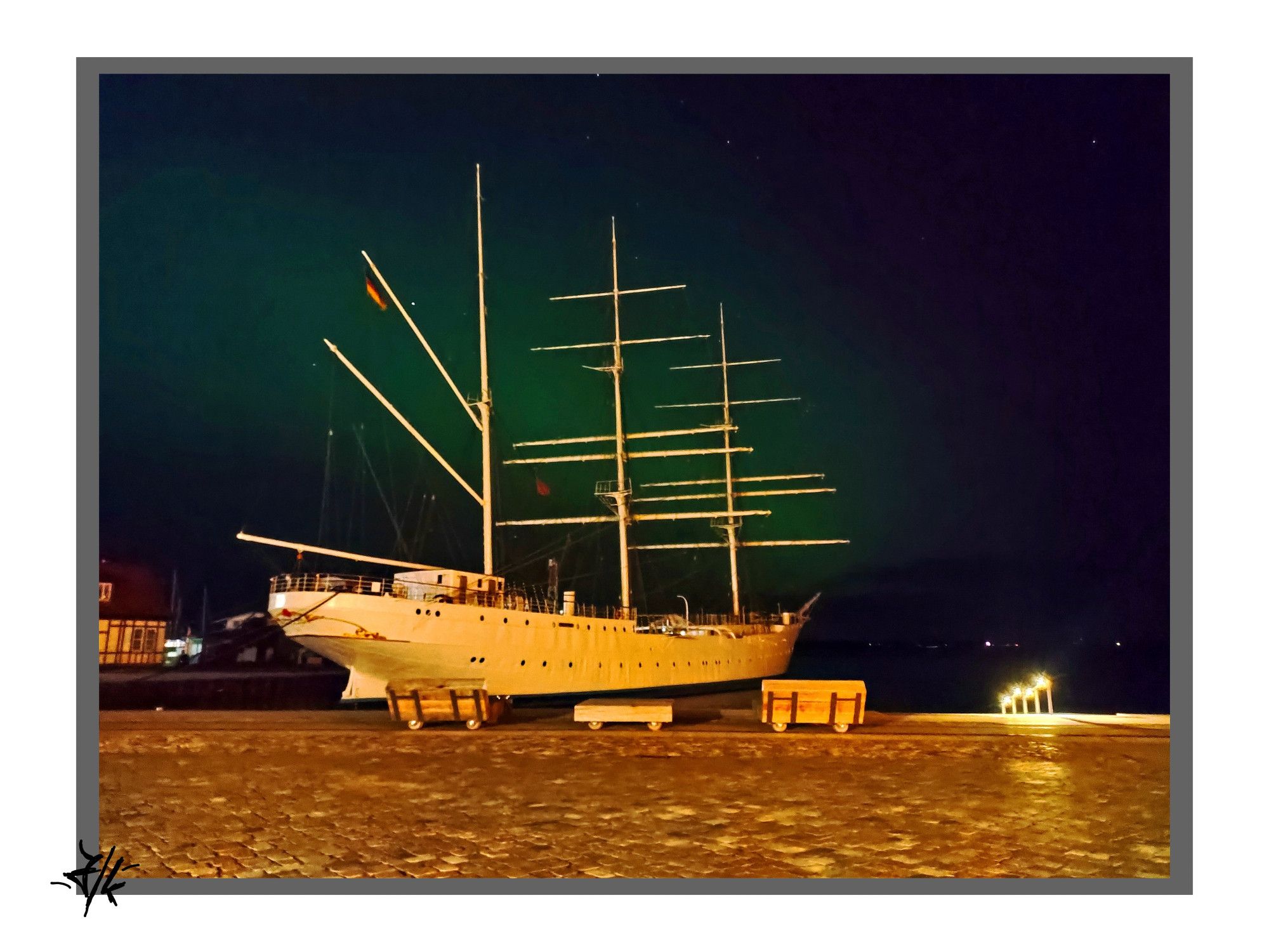 Foto von der Gorch Fock I im Hafen von Stralsund. Durch den nächtlichen Himmel zieht sich ein grün leuchtender Streifen, bin mir nicht Sicher ob's Polarlichter sind.