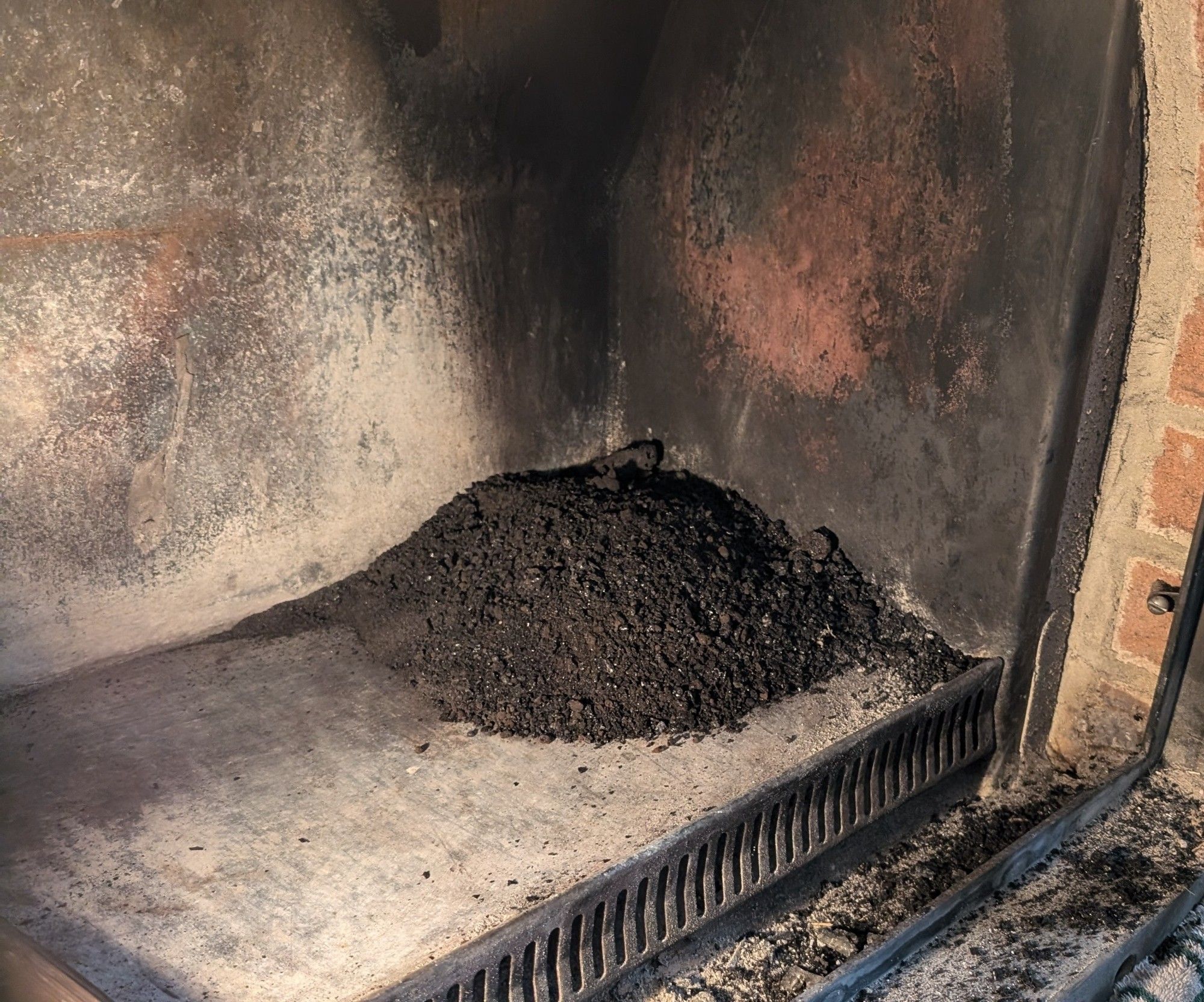 Fireplace with a pile of creosote and other crud, the result of my annual chimney cleaning.