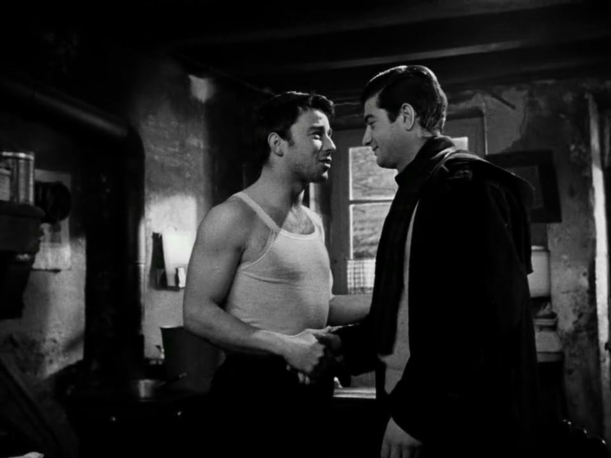 Serge (Gerard Blain) in the tank top and the fully dressed François (Jean Claude Brialy) when François drops in on his childhood friend the morning after encountering him in a drunken state.