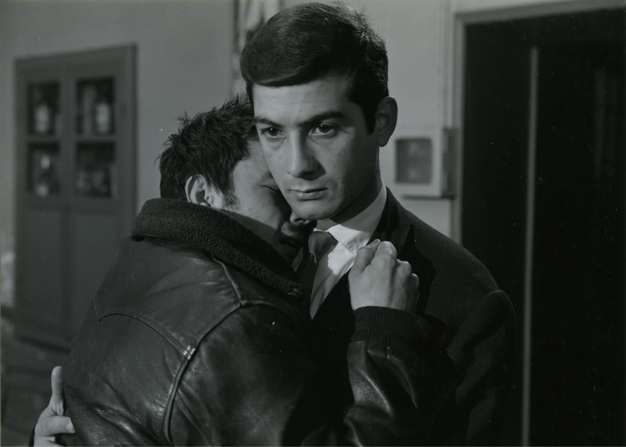 Serge (Gerard Blain) in the leather jacket crying on the shoulder of François (Jean Claude Brialy) in a brief reunion when François returns to town, meeting his childhood friend in a drunken state.